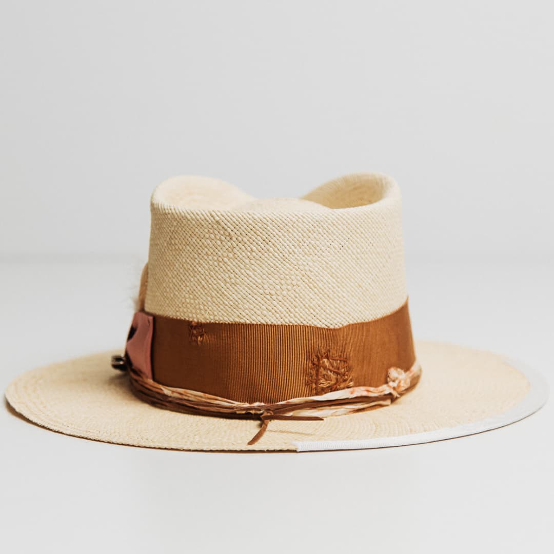 Back view of Malibu Panama hat featuring tan chicken feathers and Copper grosgrain band.