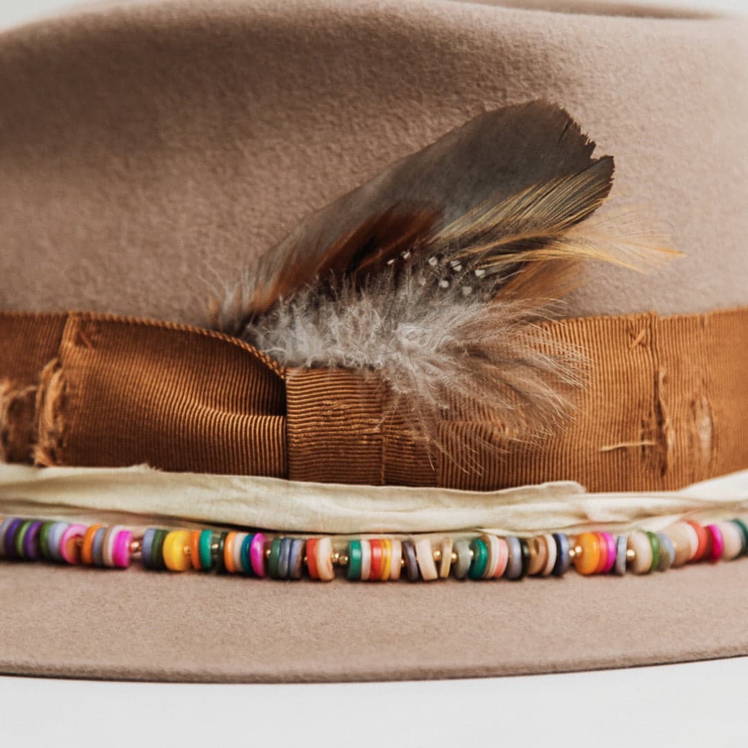 Close up detail of the Mango felt hat showing copper grosgrain bow with fallen feather bunch.