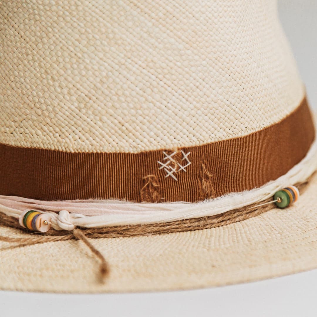 Close up detail of the Mango Panama hat showing twine wrap with rainbow disc bead clusters and ivory sari silk trim.