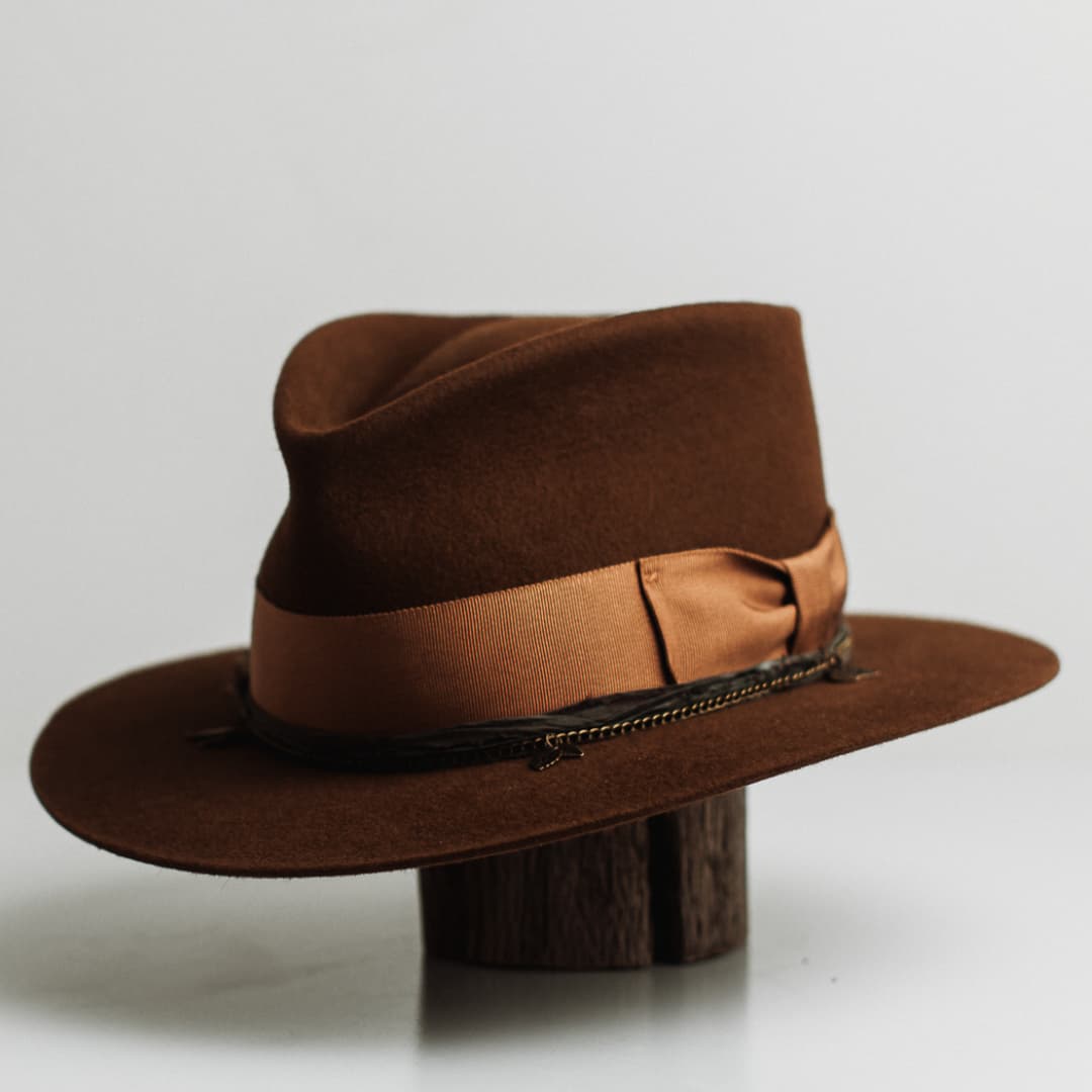 Front left angle of the Maple caramel felt hat by PHYLLi Designs with copper grosgrain band, sari silk trim in Eggplant and bronze crown chain.