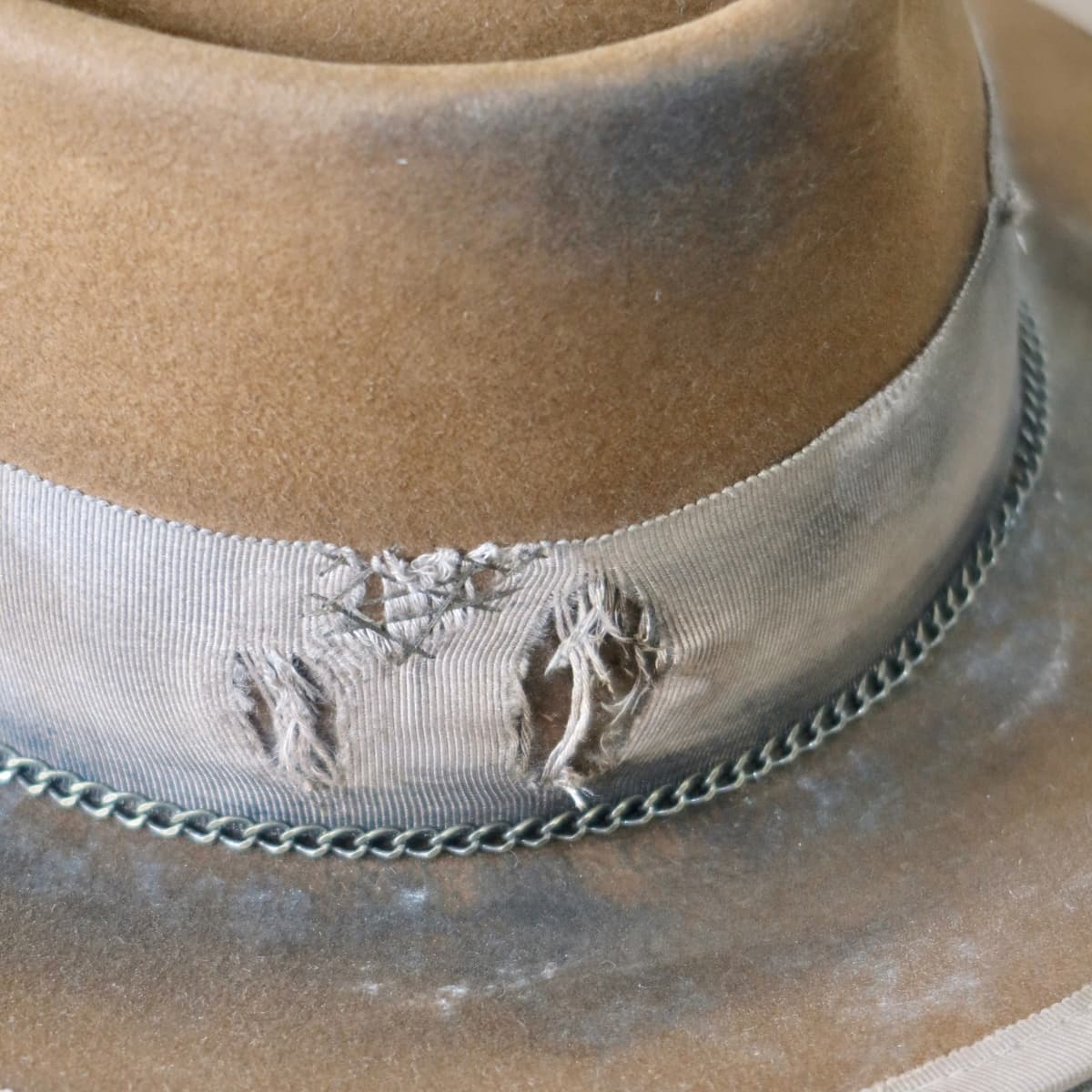 Close up detail of the Marlboro felt hat showing hand distressed grosgrain band with visible patchwork stitching.