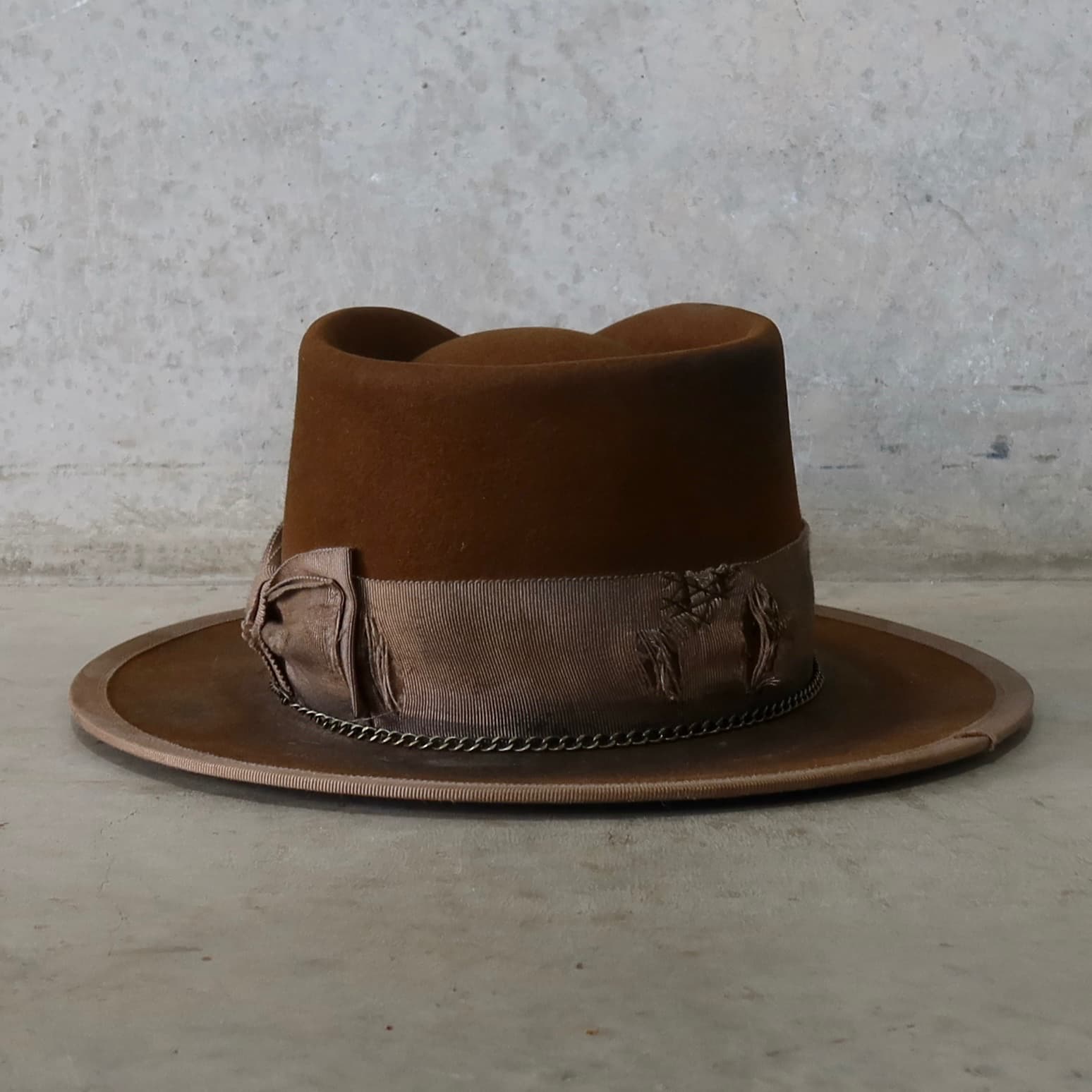Back view of the Marlboro Caramel distressed felt hat by PHYLLi Designs featuring distressed taupe Japanese grosgrain double bow.