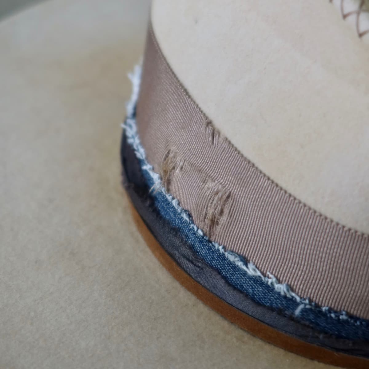 Close up detail of the McVeigh felt hat showing navy sari silk and denim trim tied with tan suede string.
