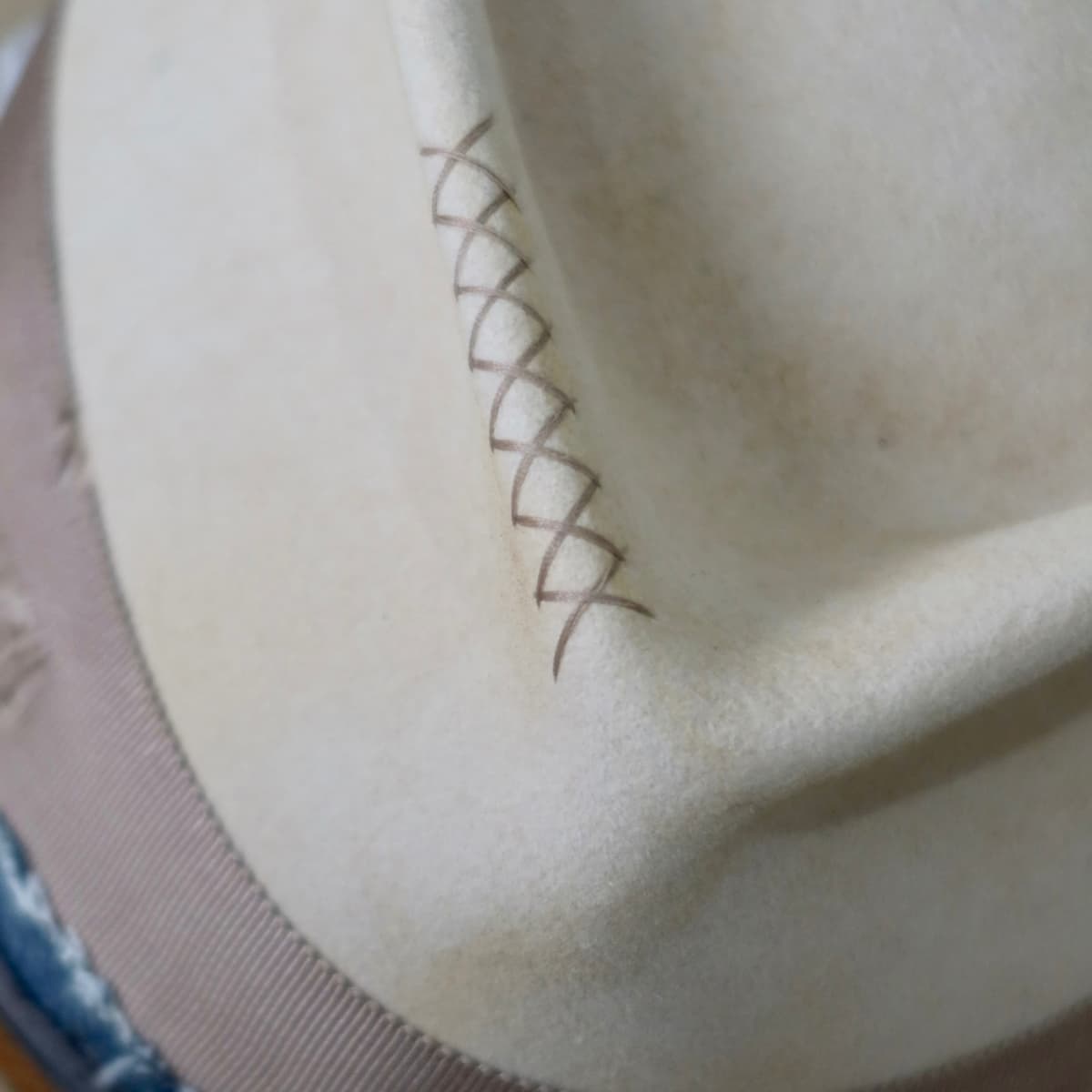Close up detail of the McVeigh felt hat showing taupe hand-stitched crosses on the front crown.