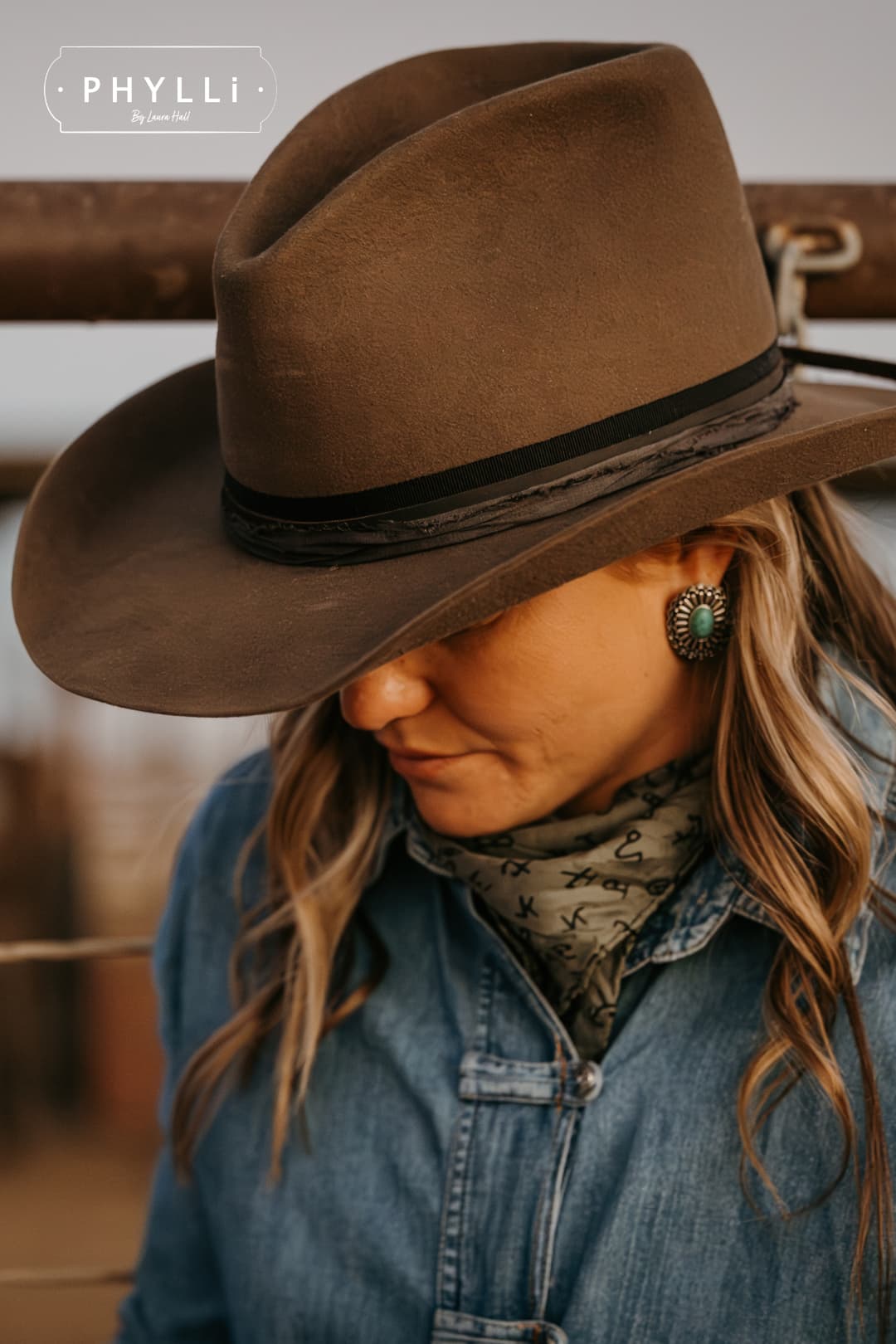 Close up woman wearing the Midnight Cowboy dirty olive felt cowboy hat by PHYLLi Designs with black Japanese grosgrain ribbon band and midnight sari silk trim in rural cattle yards.