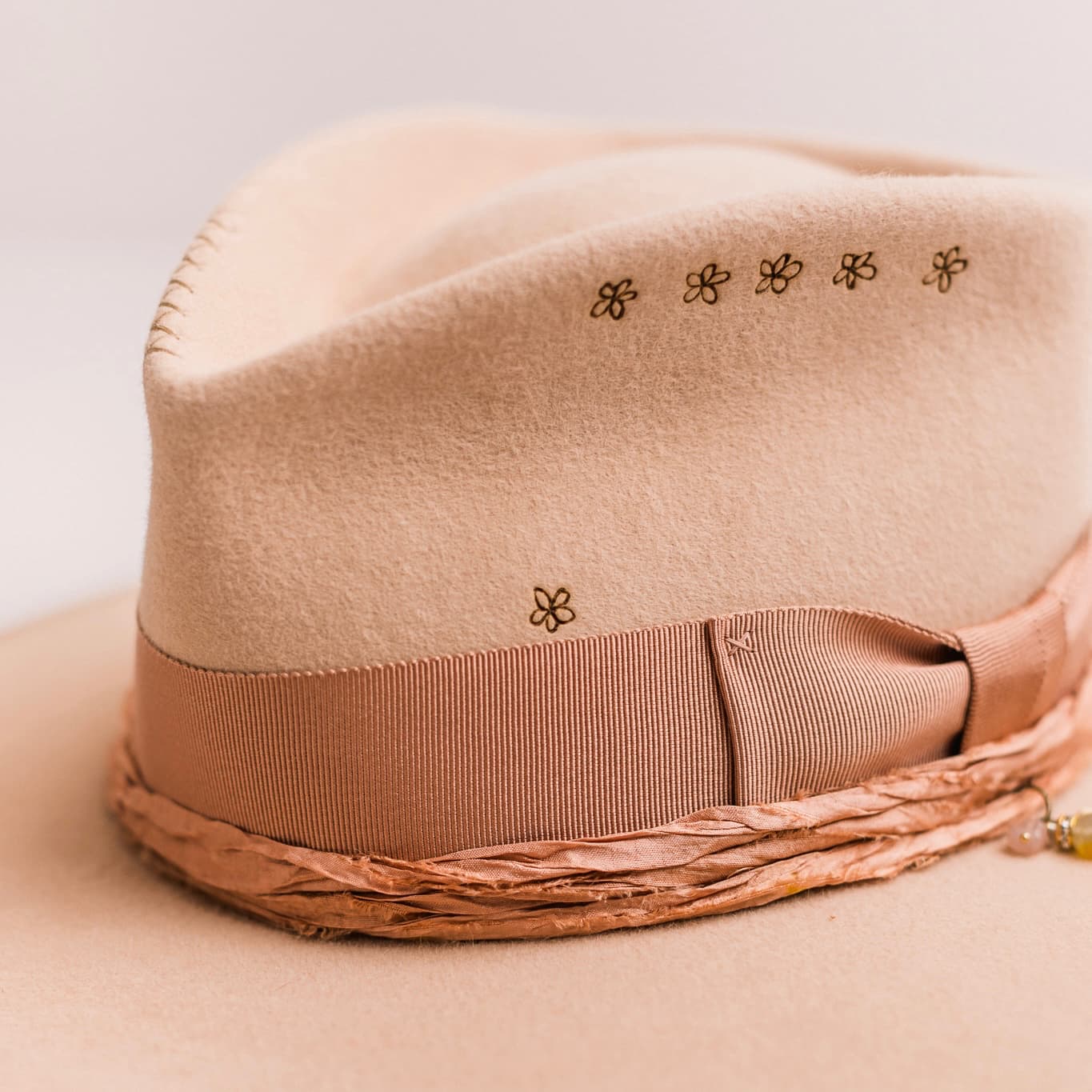 Close up detail of the Miley felt hat showing dirty rose Japanese grosgrain band and sari silk trim.