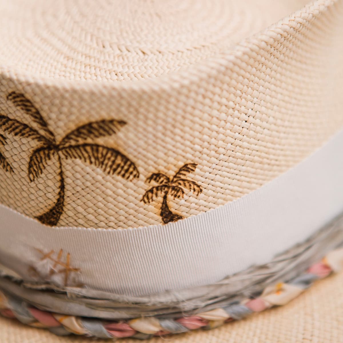 Close up detail of the My Magical Panama hat showing burnt branded palm trees on the crown.