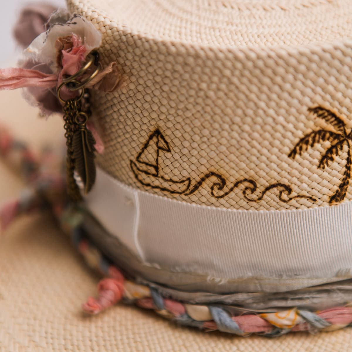 Close up detail of the My Magical Panama hat showing burnt branded boat and wave motif on the crown.