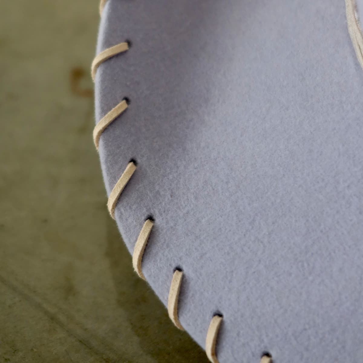 Close up detail of the Nevada cowboy hat showing nude suede brim lacing stitched through the lilac felt brim.