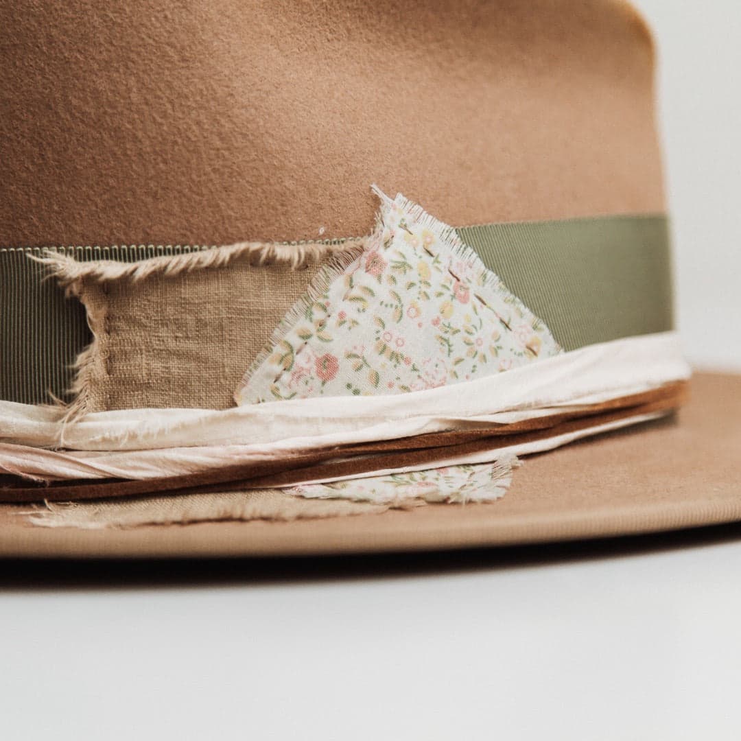 Close up detail of the Nim felt hat showing floral and linen patches with tan suede string.