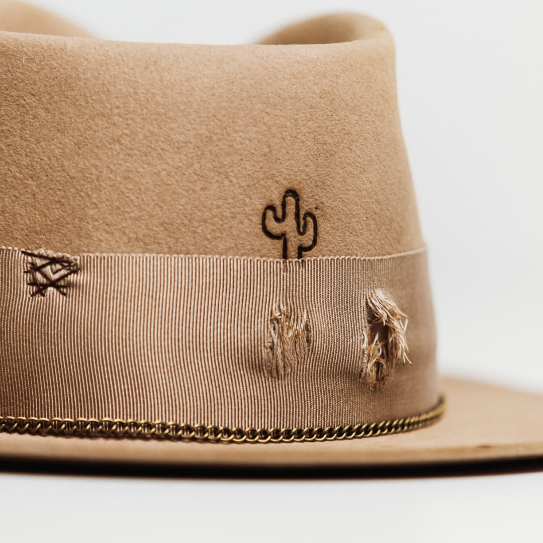 Close up detail of the Normie felt hat showing burnt branded cactus and distressed grosgrain band.