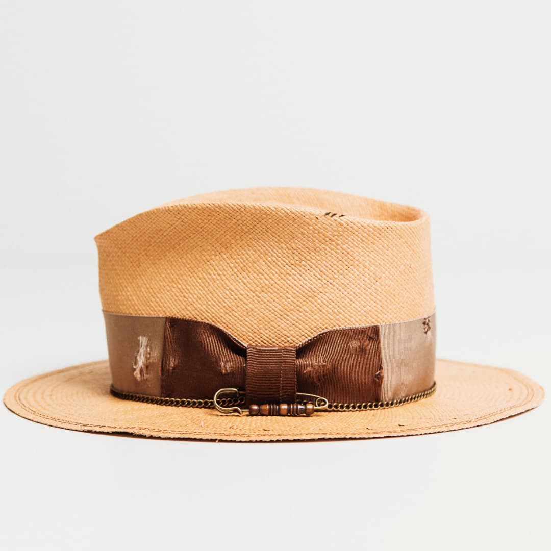 Side view of Normie Panama hat with distressed grosgrain band, darned patches and bronze crown chain.