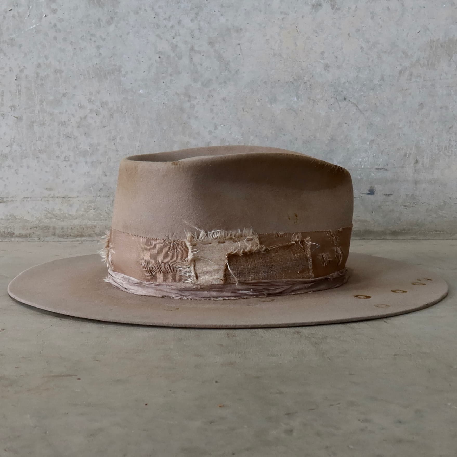 Right side view of the Sahara felt hat Oakley Limited Edition by PHYLLi Designs with distressed taupe grosgrain band, sari silk trim and worn patchwork detailing.