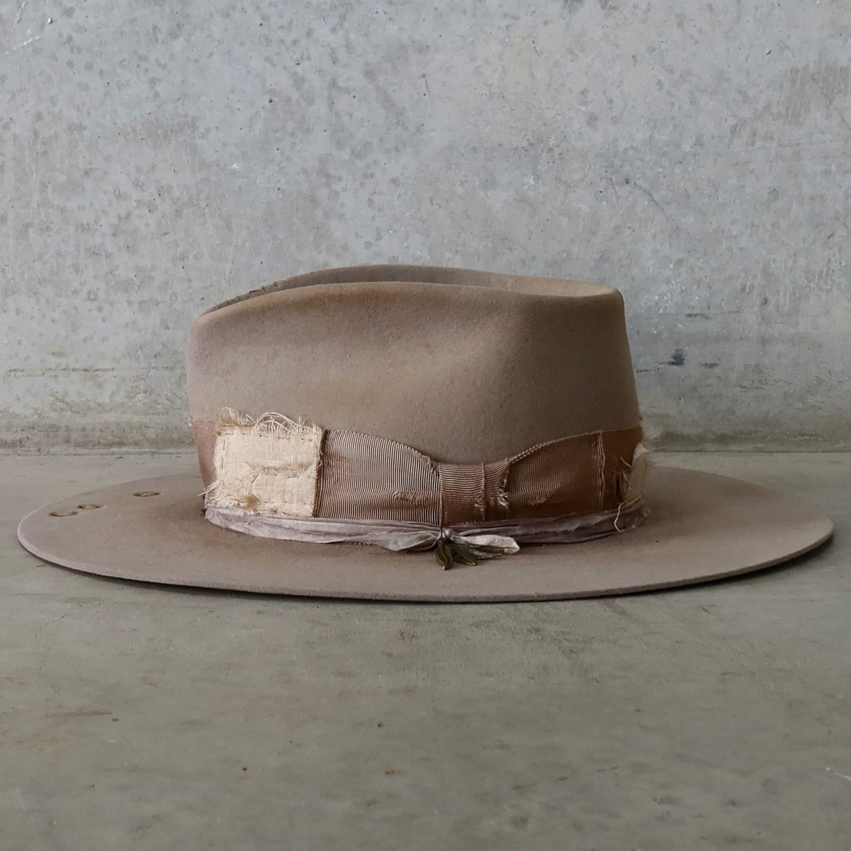 Left side view of the Sahara felt hat Oakley Limited Edition by PHYLLi Designs featuring bronze charm cluster and sari silk trim.