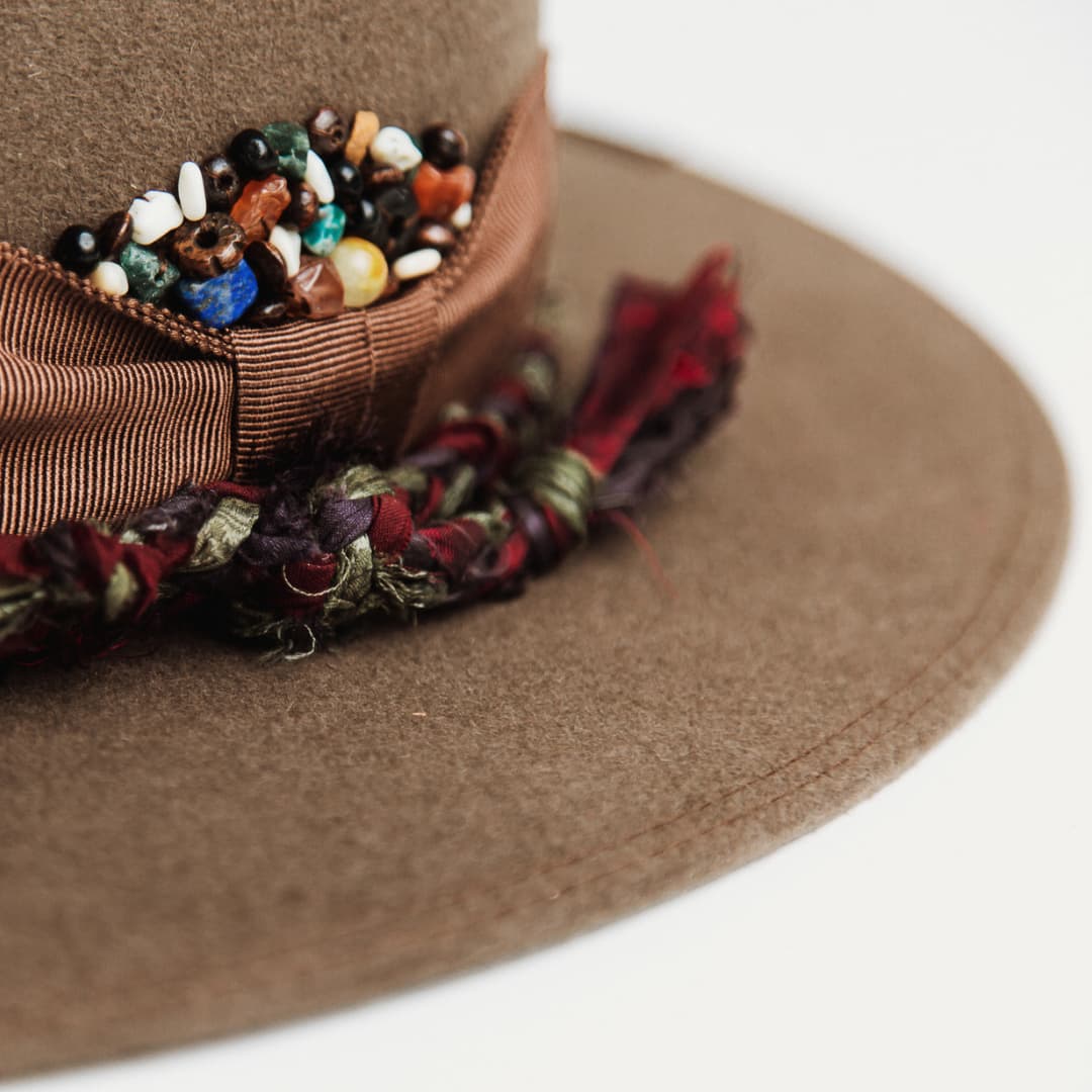 Close up detail of the Olive Enchanted felt hat showing assorted bead cluster in quartz crystals, timber and bone.