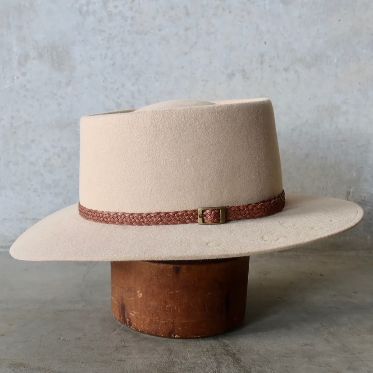 Left side view of the Sand felt hat Paisley by PHYLLi Designs with eight strand plaited leather hat band in chocolate.