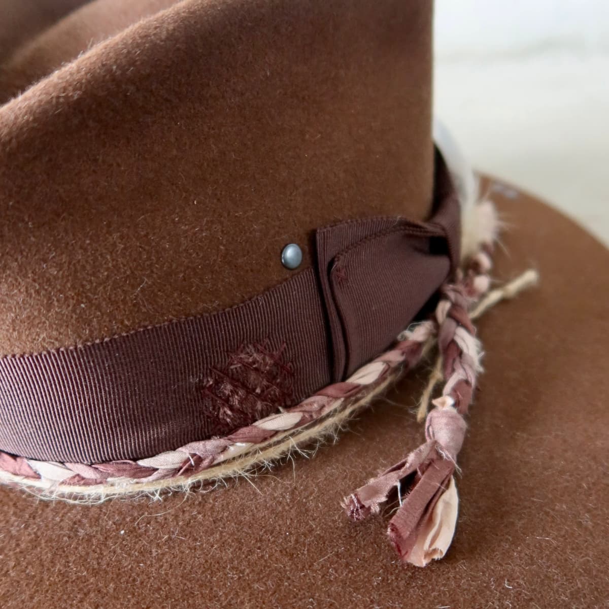 Close up detail of the Palmer Limited Edition felt hat showing distressed Japanese grosgrain band with darned patch stitching in chocolate.