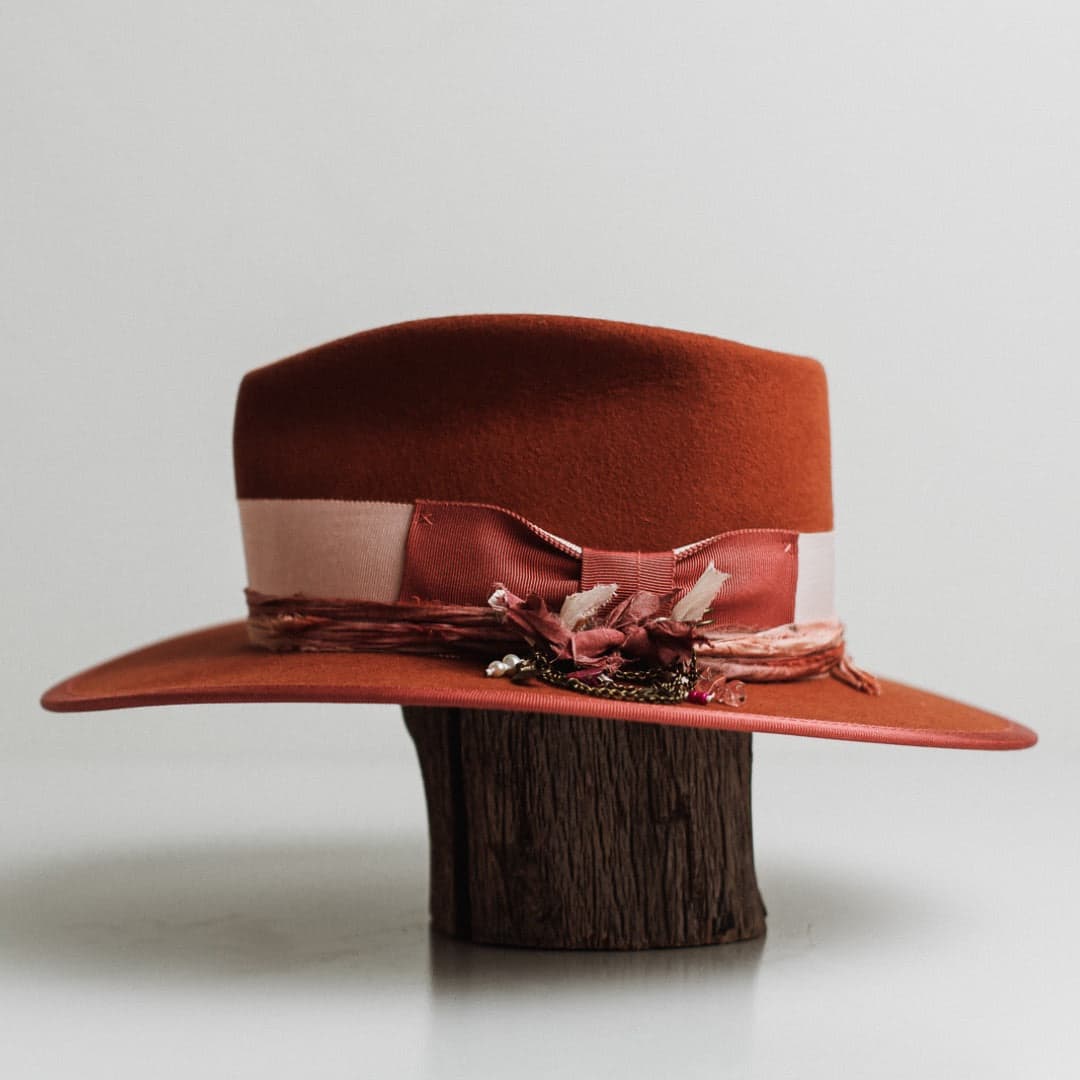 Left side view of the Pamela spiced pumpkin felt hat by PHYLLi Designs with pink and mauve tie-dye sari silk trimming.