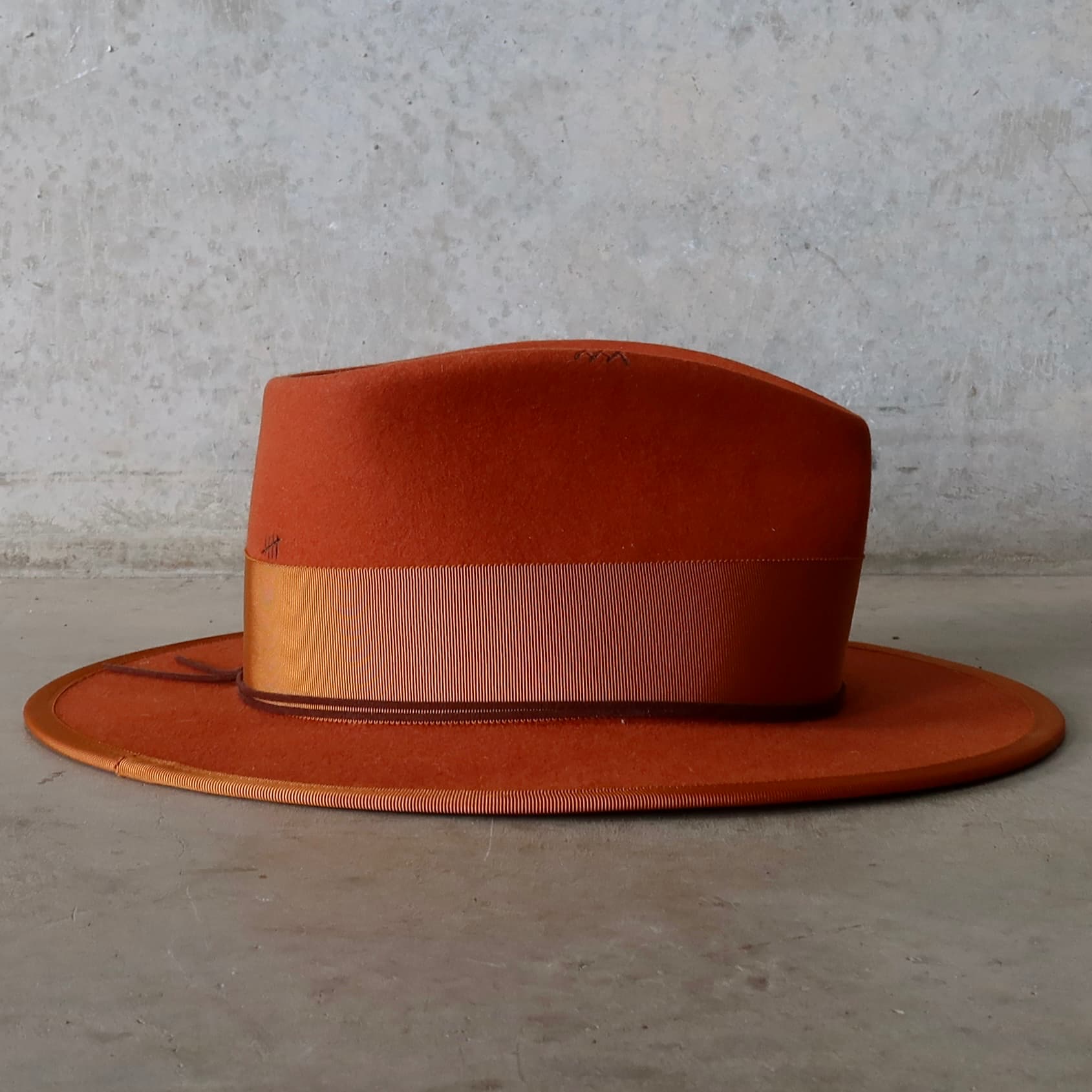 Right side view of the Patrick spiced pumpkin felt hat by PHYLLi Designs with rust Japanese grosgrain band, rust brim trim and chocolate suede string.