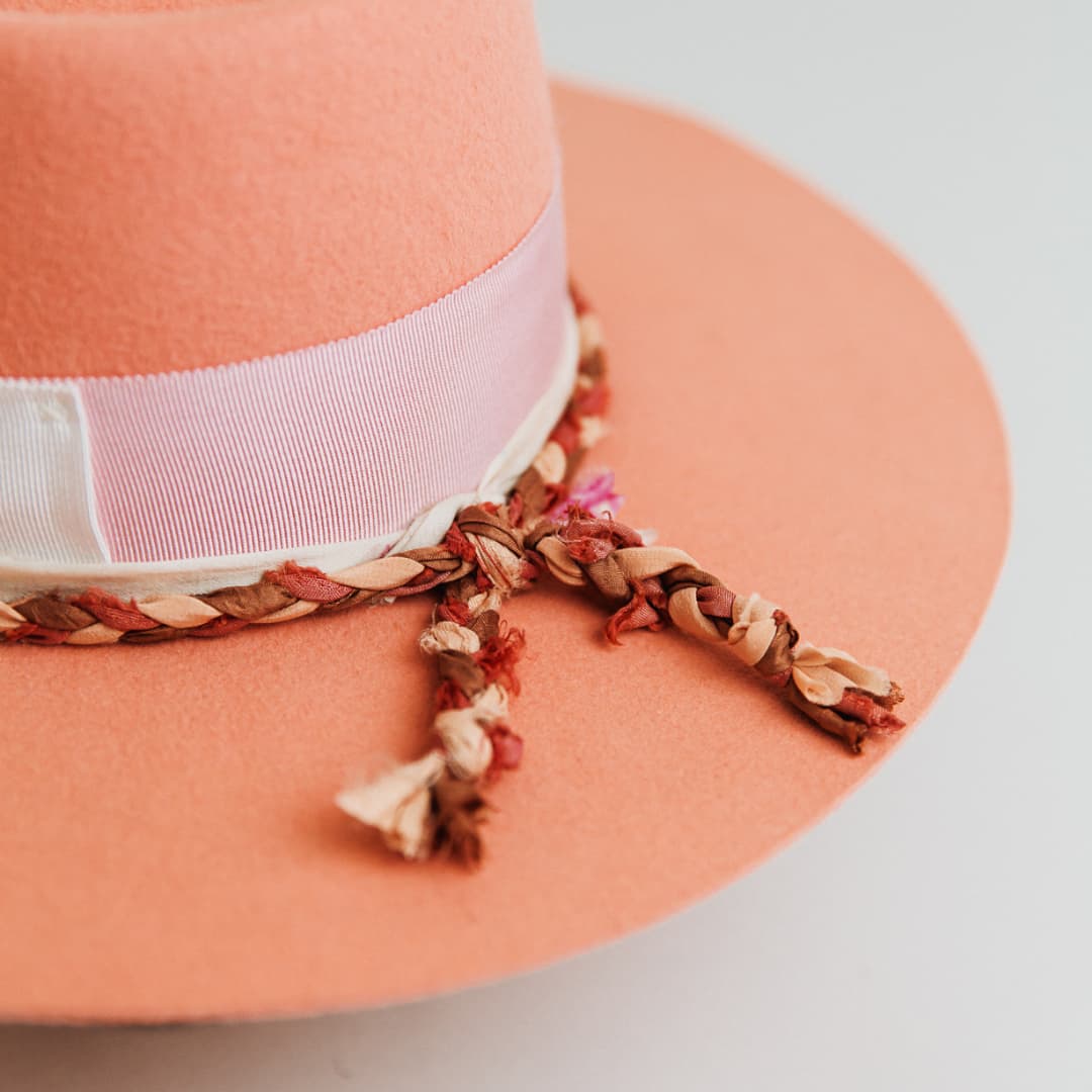 Close up detail of The Peach felt hat by PHYLLi Designs featuring hand-stitched crosses in ivory and sari silk trimming.