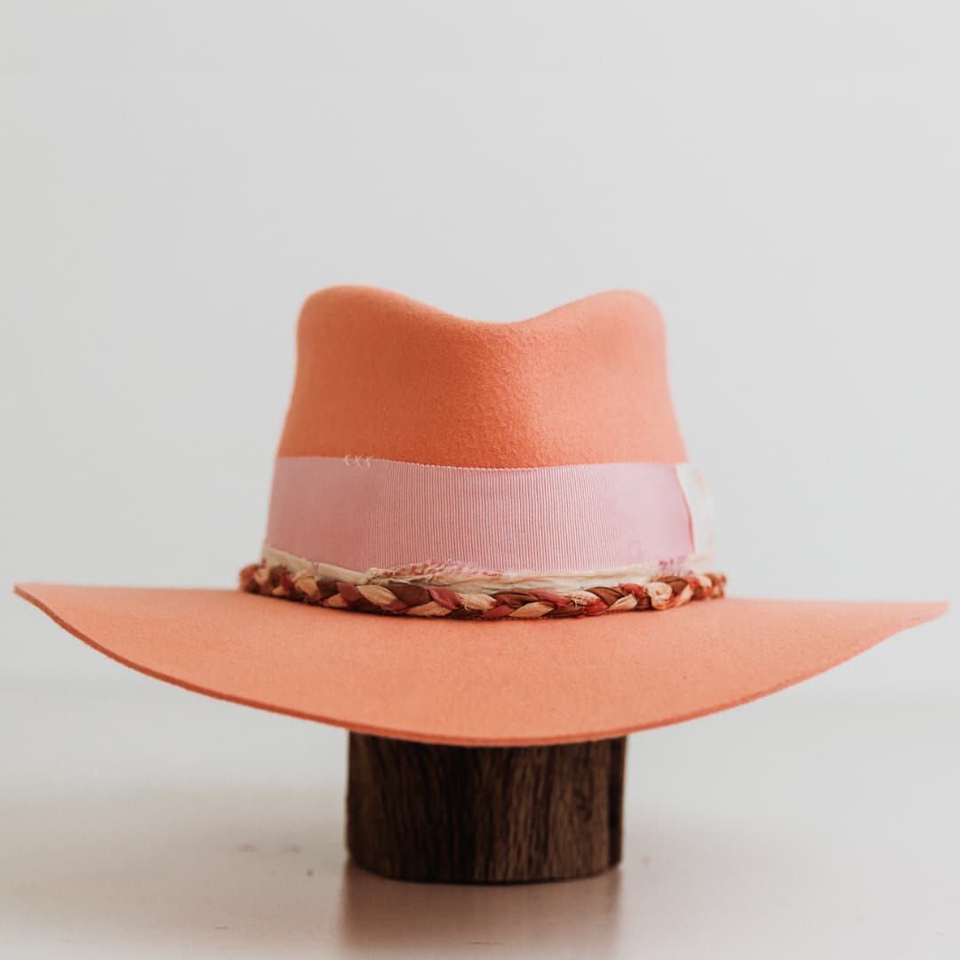 Front view of The Peach felt hat by PHYLLi Designs with floss pink Japanese grosgrain band, ivory bow and plaited sari silk trim in pink, bronze and ivory.