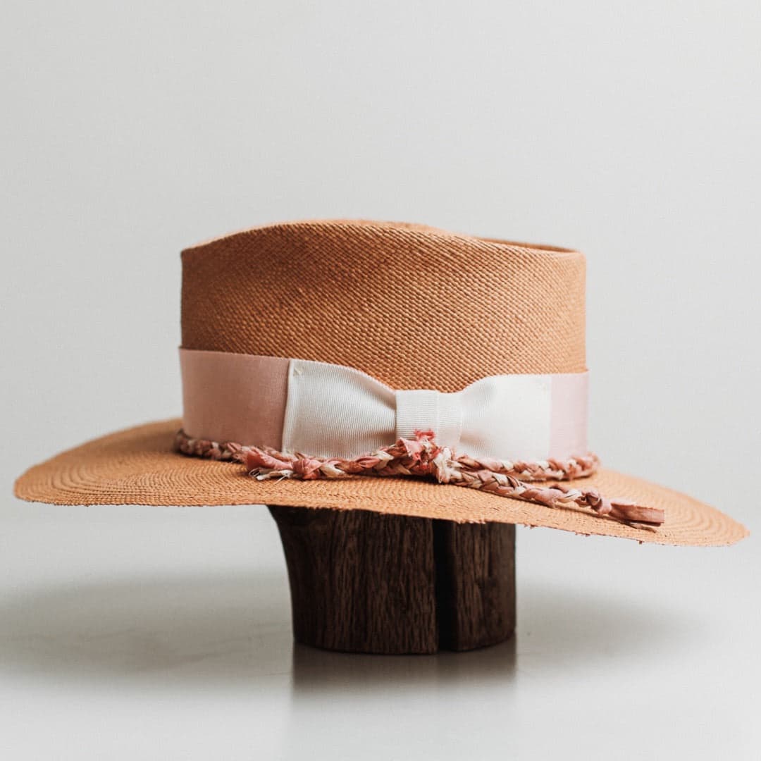 Left side view of the Peach Panama biscuit Panama hat by PHYLLi Designs featuring ivory grosgrain bow and plaited sari silk trimming.