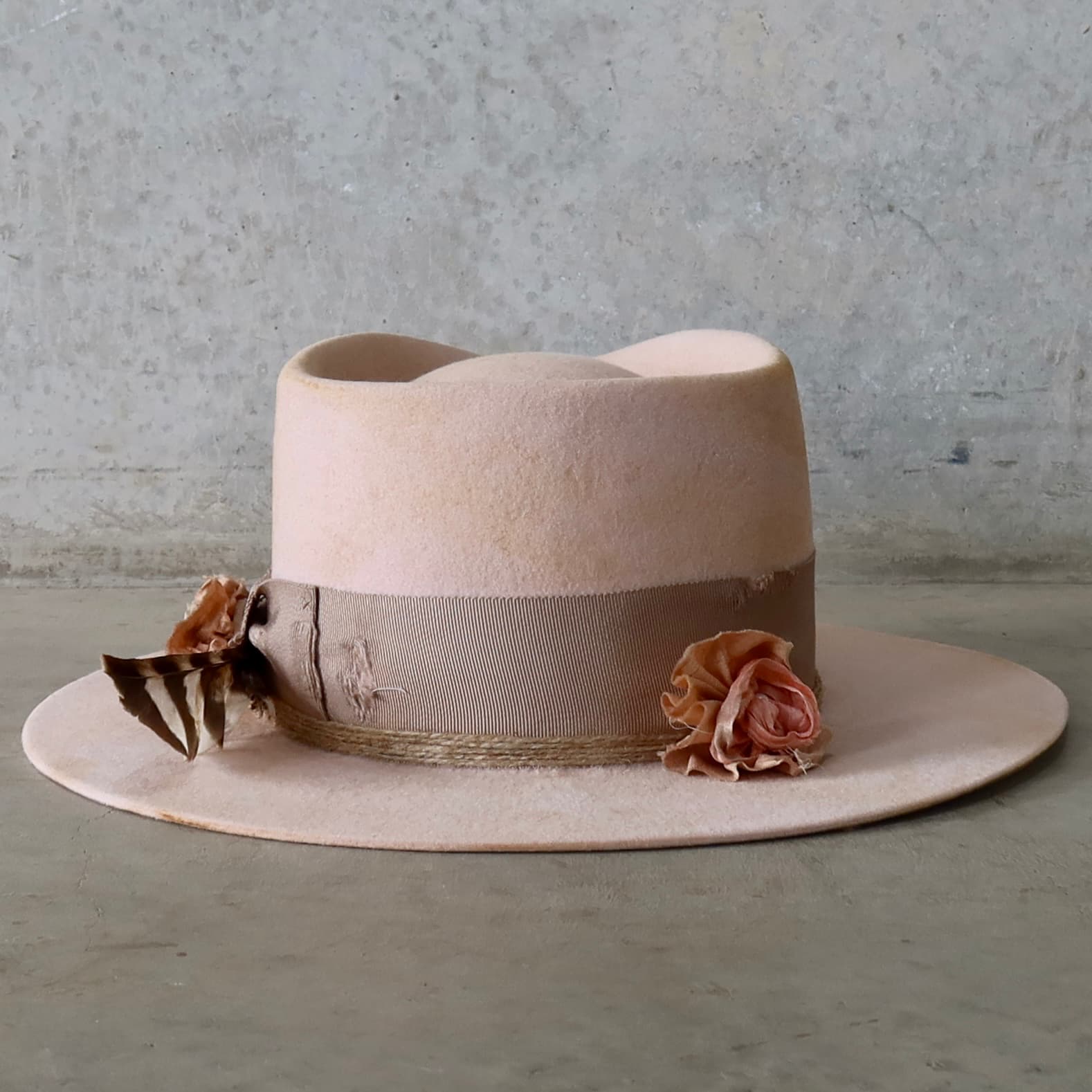 Back view of the baby pink distressed felt hat Pink Bloom by PHYLLi Designs featuring distressed taupe grosgrain bow band and twine wraps.