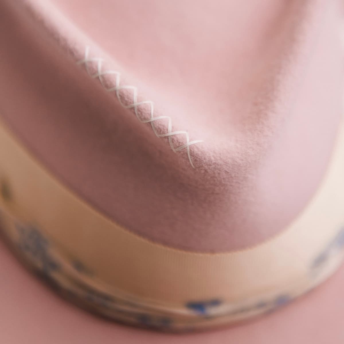 Close up detail of the Posie felt hat showing ivory hand-stitched crosses on the crown.