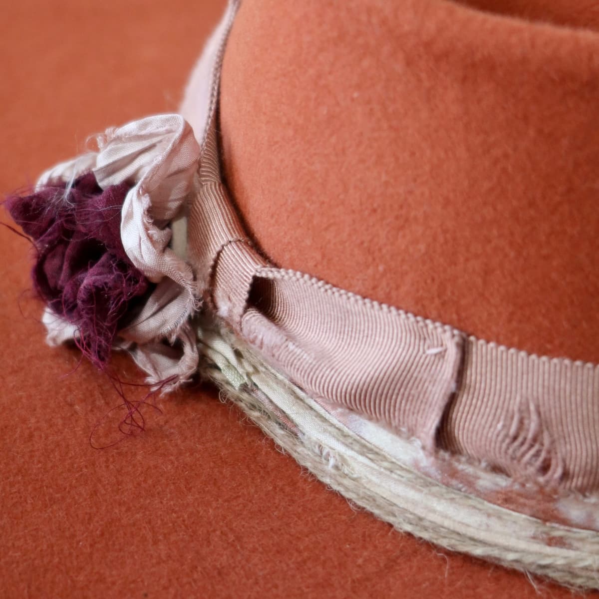 Close up detail of the Pumpkin Bloom felt hat showing sari silk lapel bloom with pearl centre.