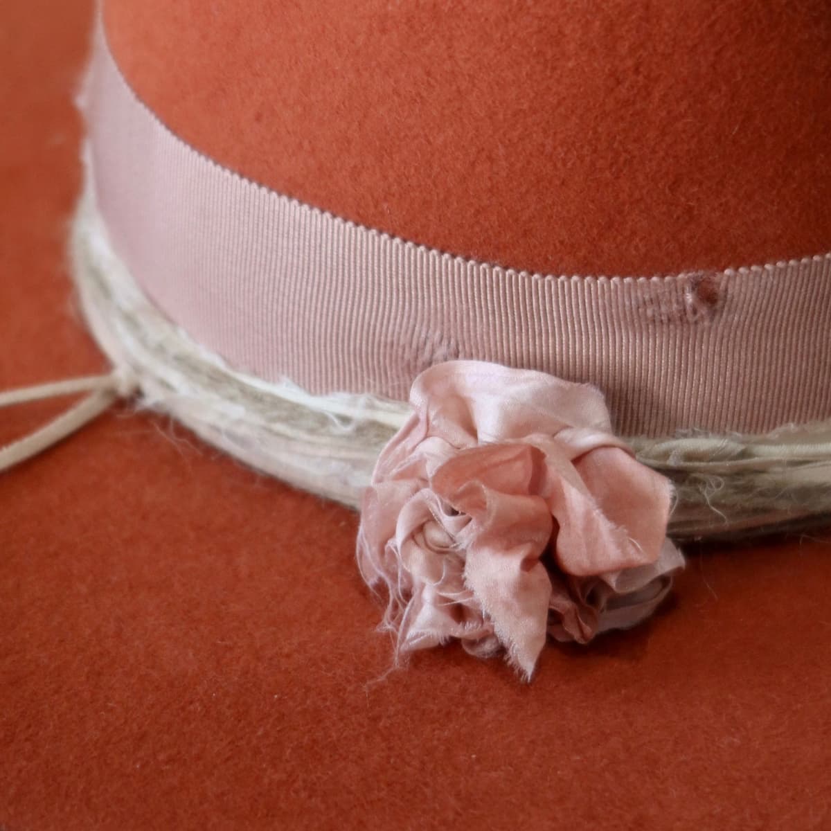 Close up detail of the Pumpkin Bloom felt hat showing sari silk lapel bloom in rose and cream tones.