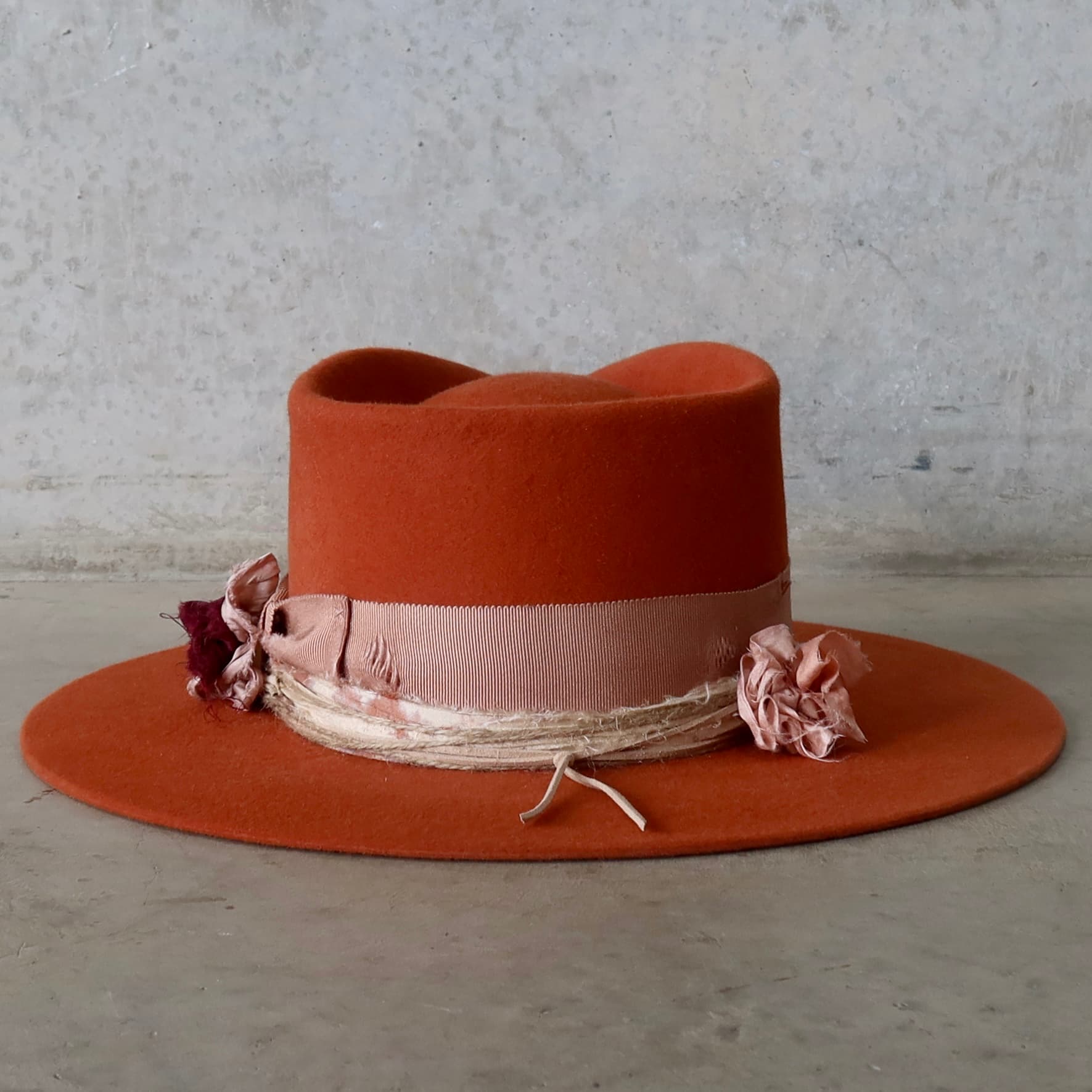 Back view of the spiced pumpkin felt hat Pumpkin Bloom by PHYLLi Designs featuring distressed dirty rose grosgrain bow band and twine wraps.
