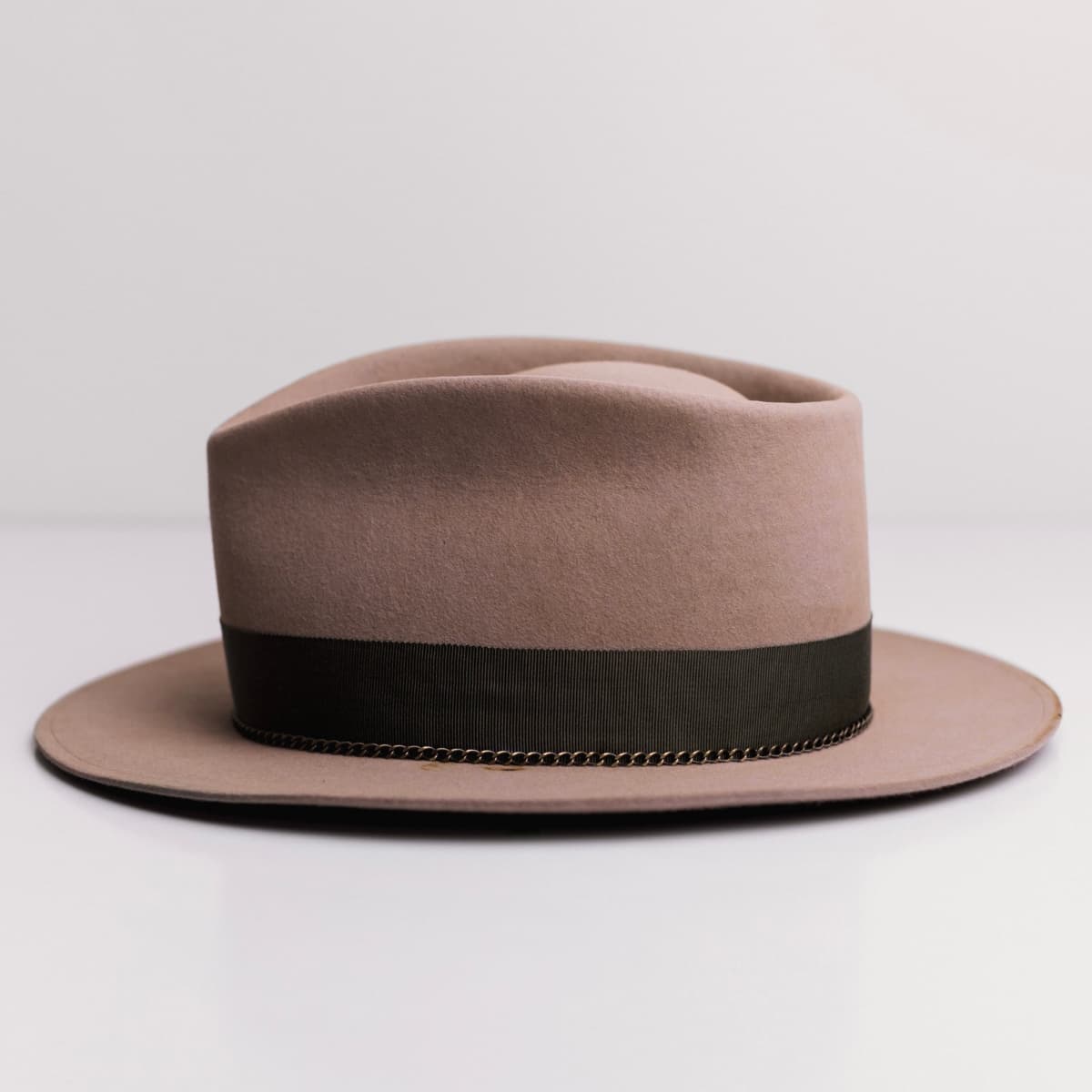 Left side view of the Sahara felt hat Reagent by PHYLLi Designs with chartreuse single brim stitch and bronze crown chain.