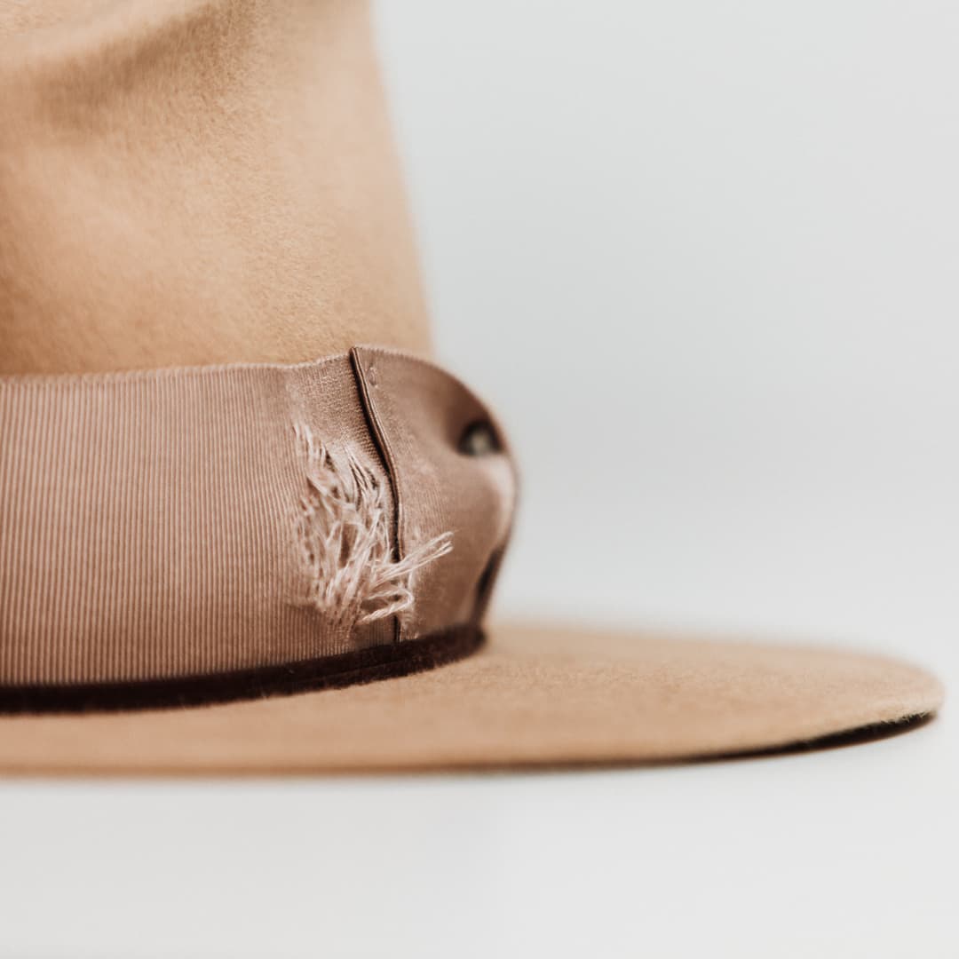 Close up detail of the Reiko felt hat showing distressed patch on the grosgrain band.