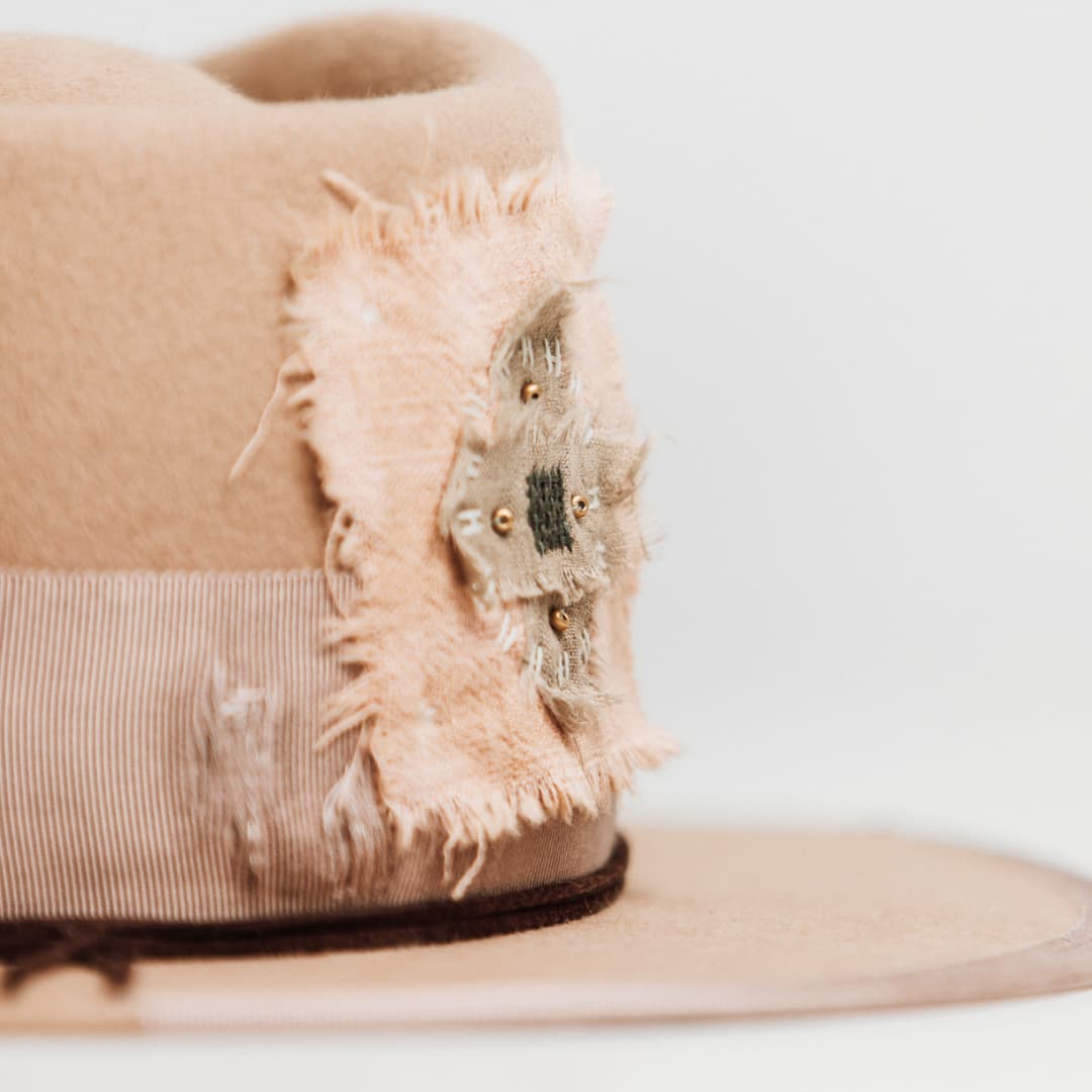 Close up detail of the Reiko felt hat showing frayed linen patch edges and layered textile stitching.