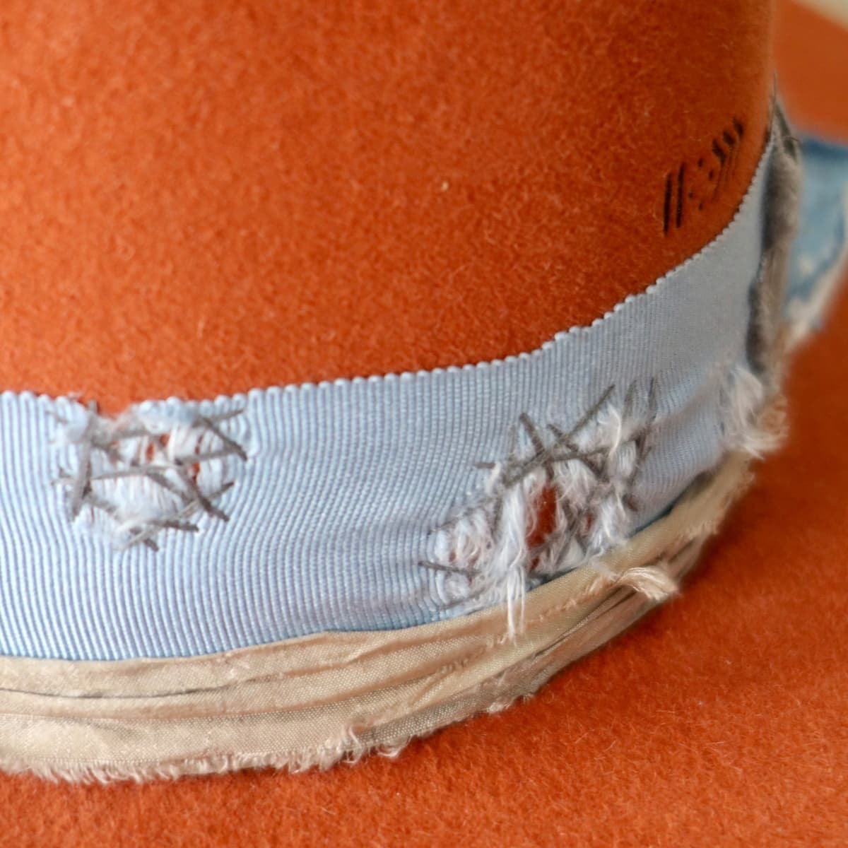 Close up detail of the Road Less Travelled felt hat showing sashiko stitched distressed grosgrain ribbon.