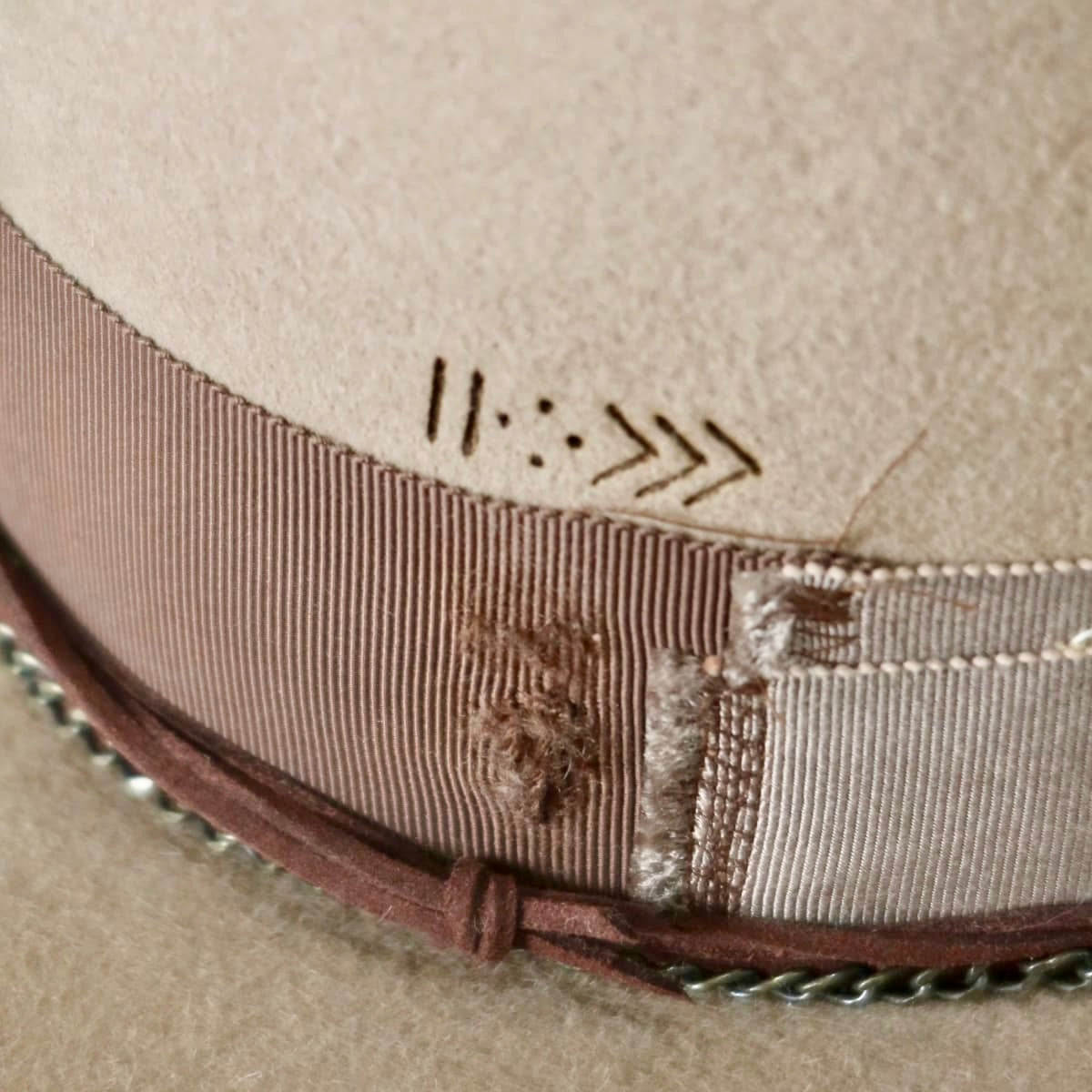 Close up of Roadie felt hat by PHYLLi Designs showing burnt branded arrow pattern on crown.