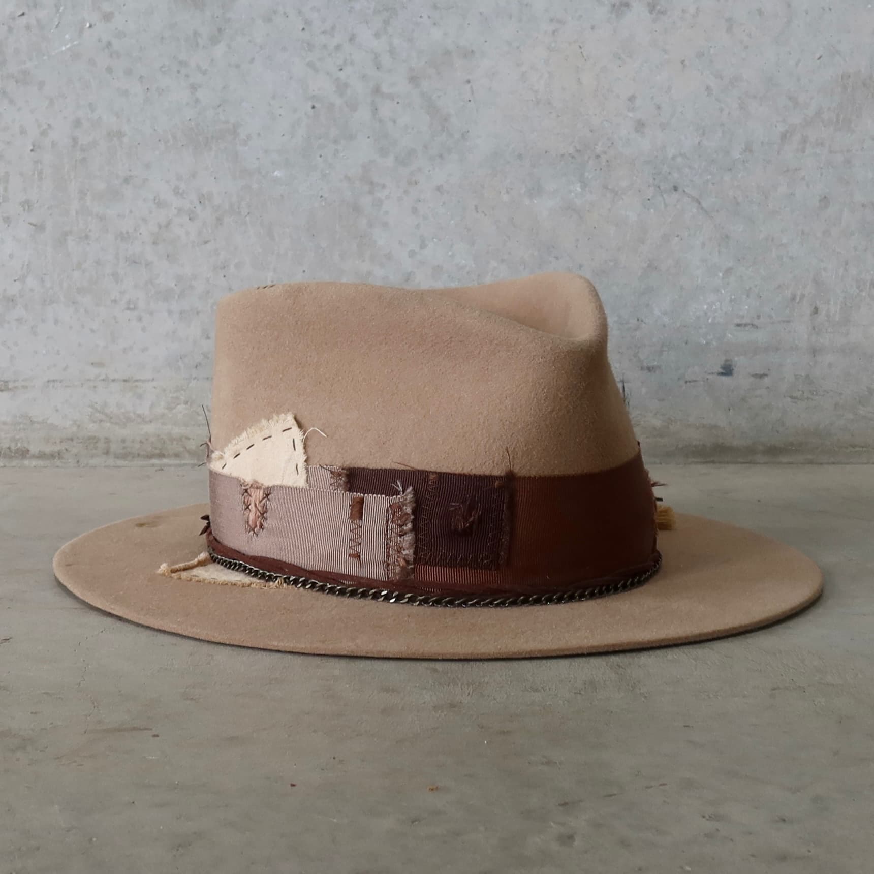 Front right angle of Roadie felt hat by PHYLLi Designs with distressed grosgrain band and plaited suede string.