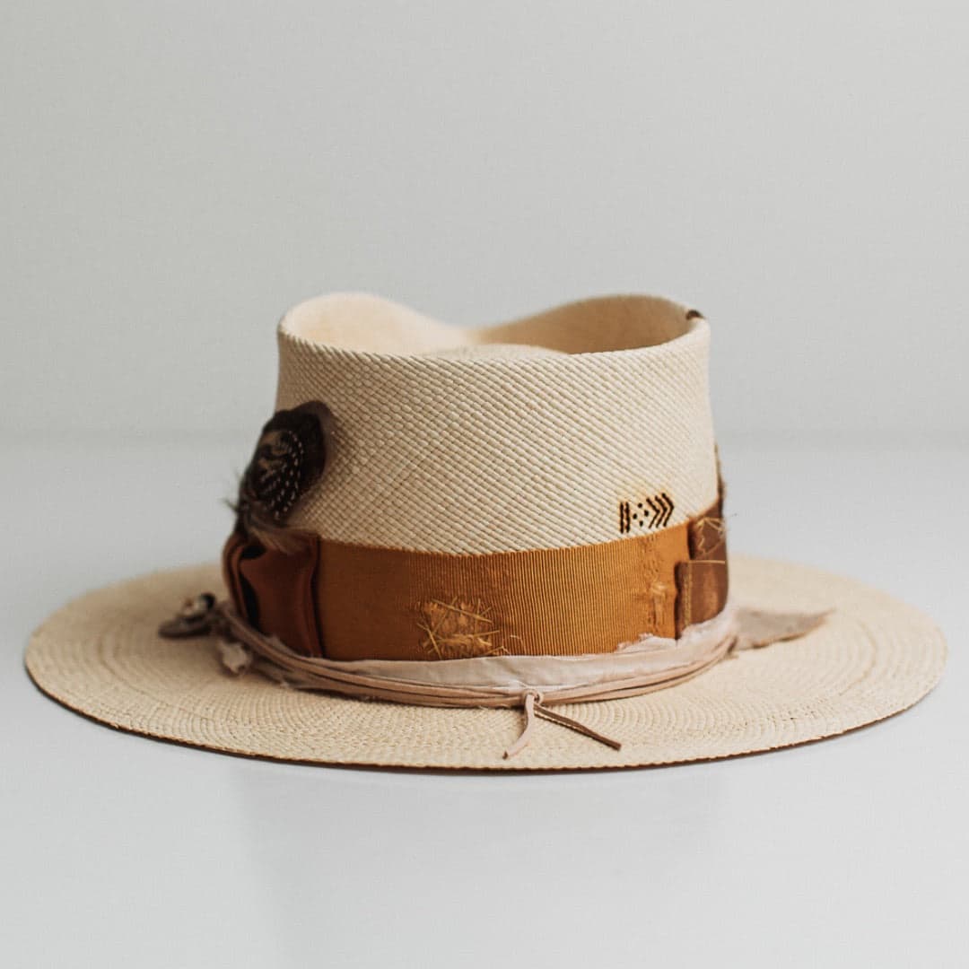 Back view of the Roadie Panama natural straw hat by PHYLLi Designs featuring ivory double brim stitch and burnt branded pattern.