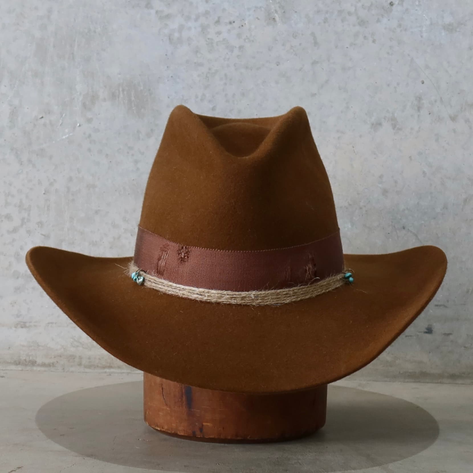 Caramel cowboy hat Rue by PHYLLi Designs with distressed chocolate Japanese grosgrain band and turquoise beaded twine wraps.