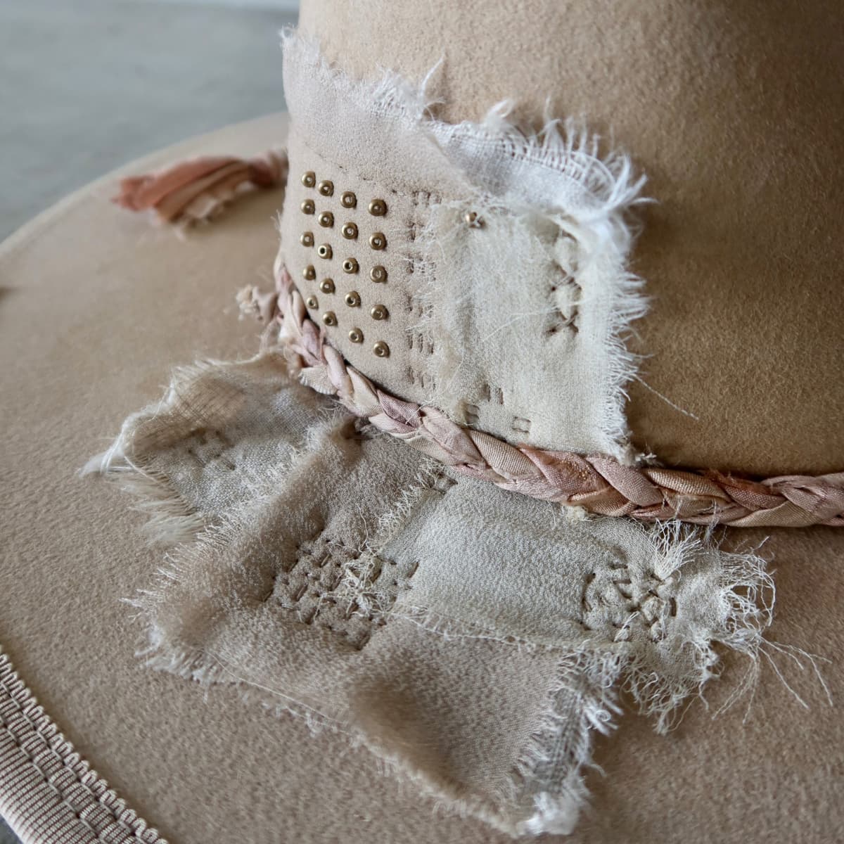 Close up detail of the Ryoan Limited Edition felt hat showing Wabi Sabi linen and silk patches finished with gold beading.