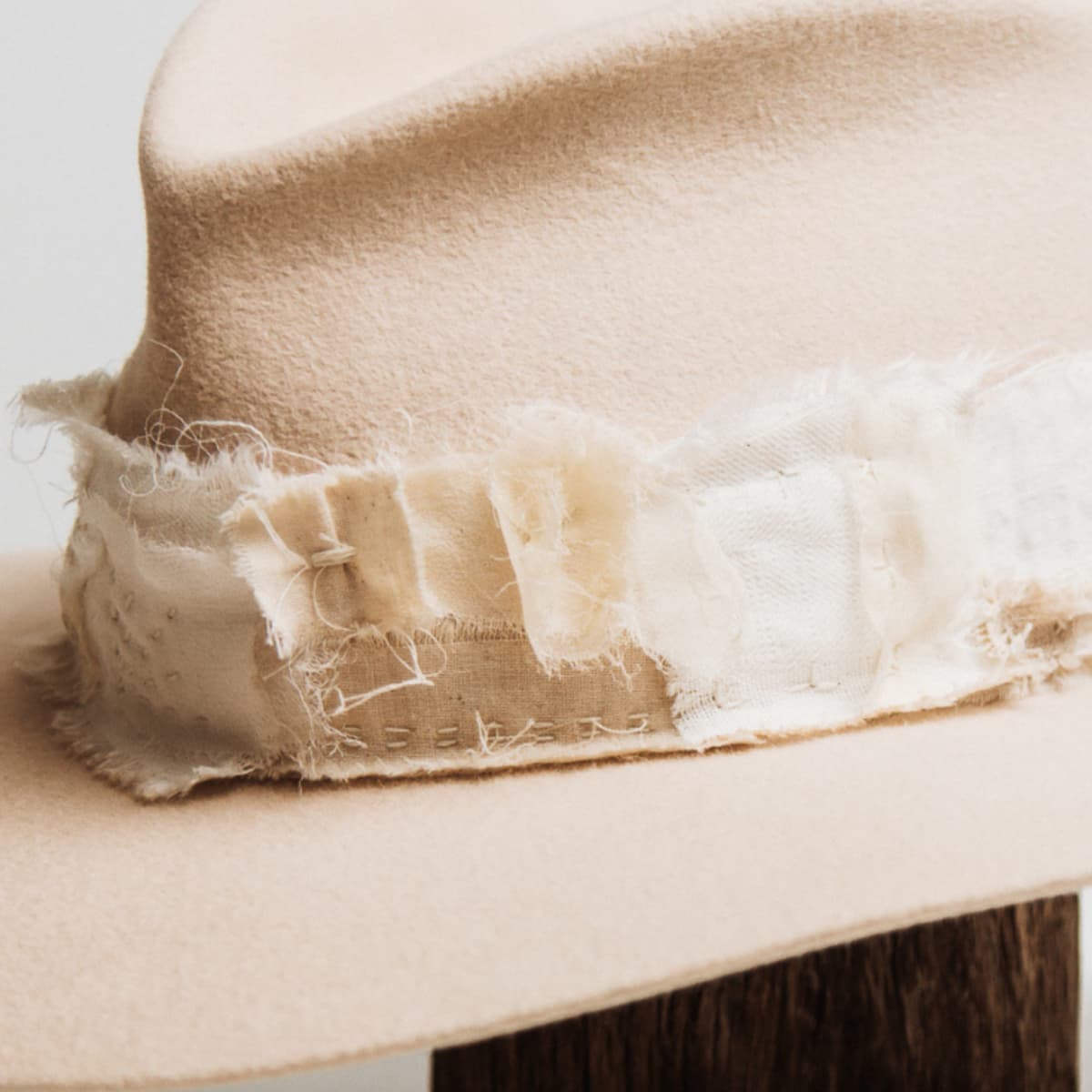 Close up detail of the Sabi Limited Edition felt hat showing silk pocket detail with matte gold beads and hand stitched patchwork band.