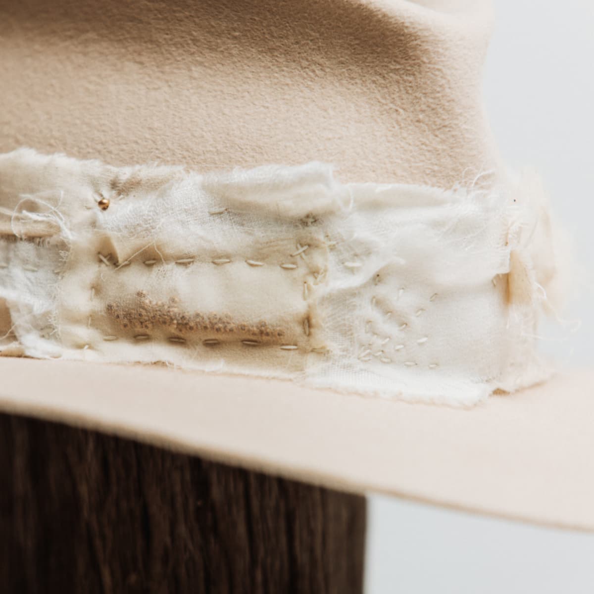 Close up detail of the Sabi Limited Edition felt hat showing sashiko stitching in Ivory, Cream, Stone and Bone across layered fabric patches.