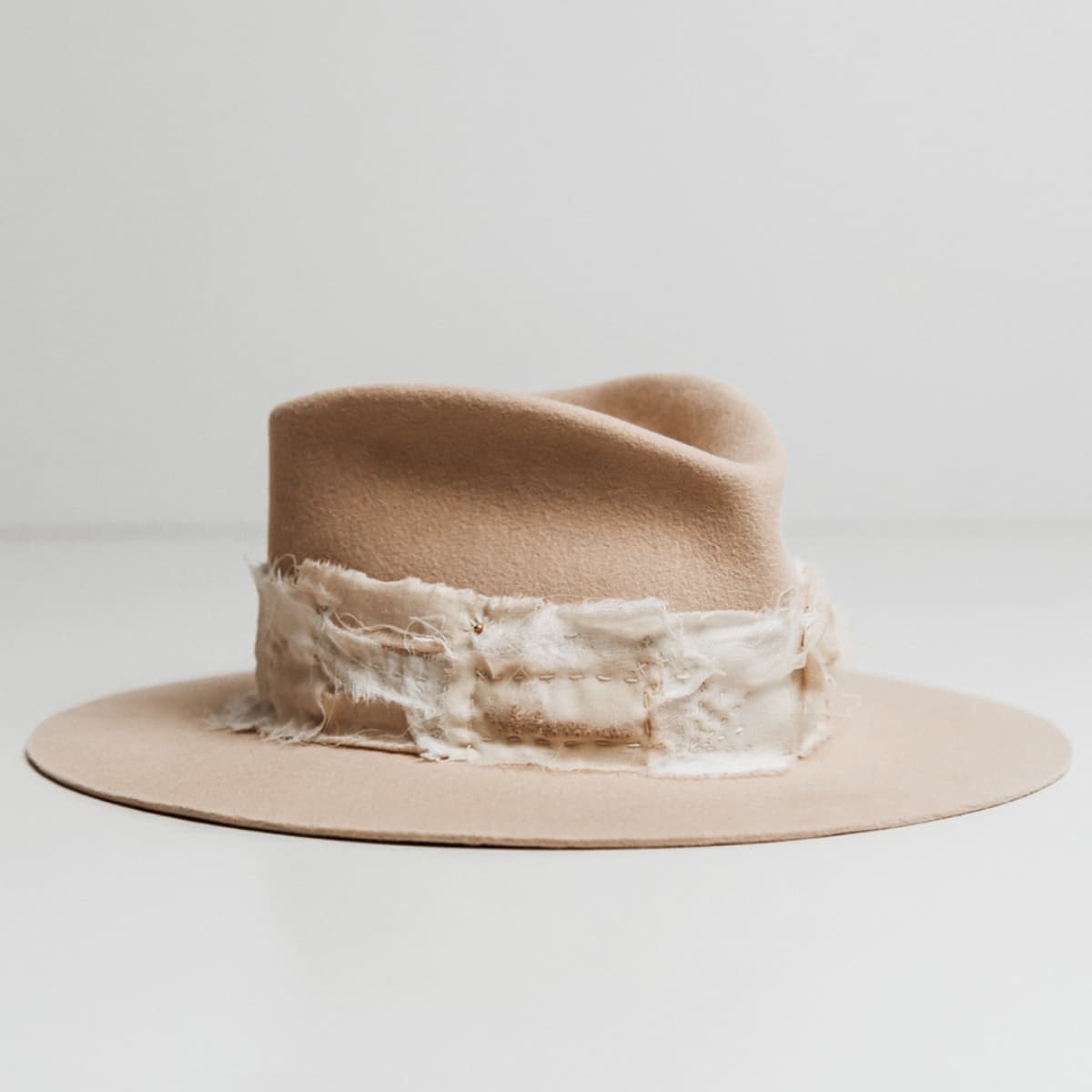 Front right angle of the Sabi Limited Edition Beige felt hat by PHYLLi Designs with Wabi Sabi patch band in linen, cotton, organza and georgette silk.