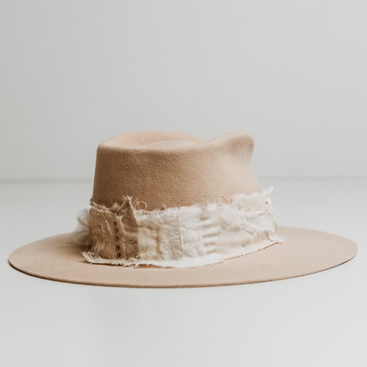Back right angle of the Sabi Limited Edition Beige felt hat by PHYLLi Designs with Wabi Sabi patch band and matte gold bead accents.