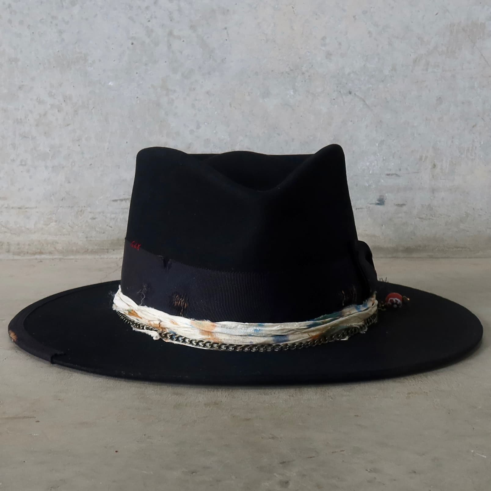 Black felt hat Saint by PHYLLi Designs with distressed black Japanese grosgrain double bow band and bronze crown chain.