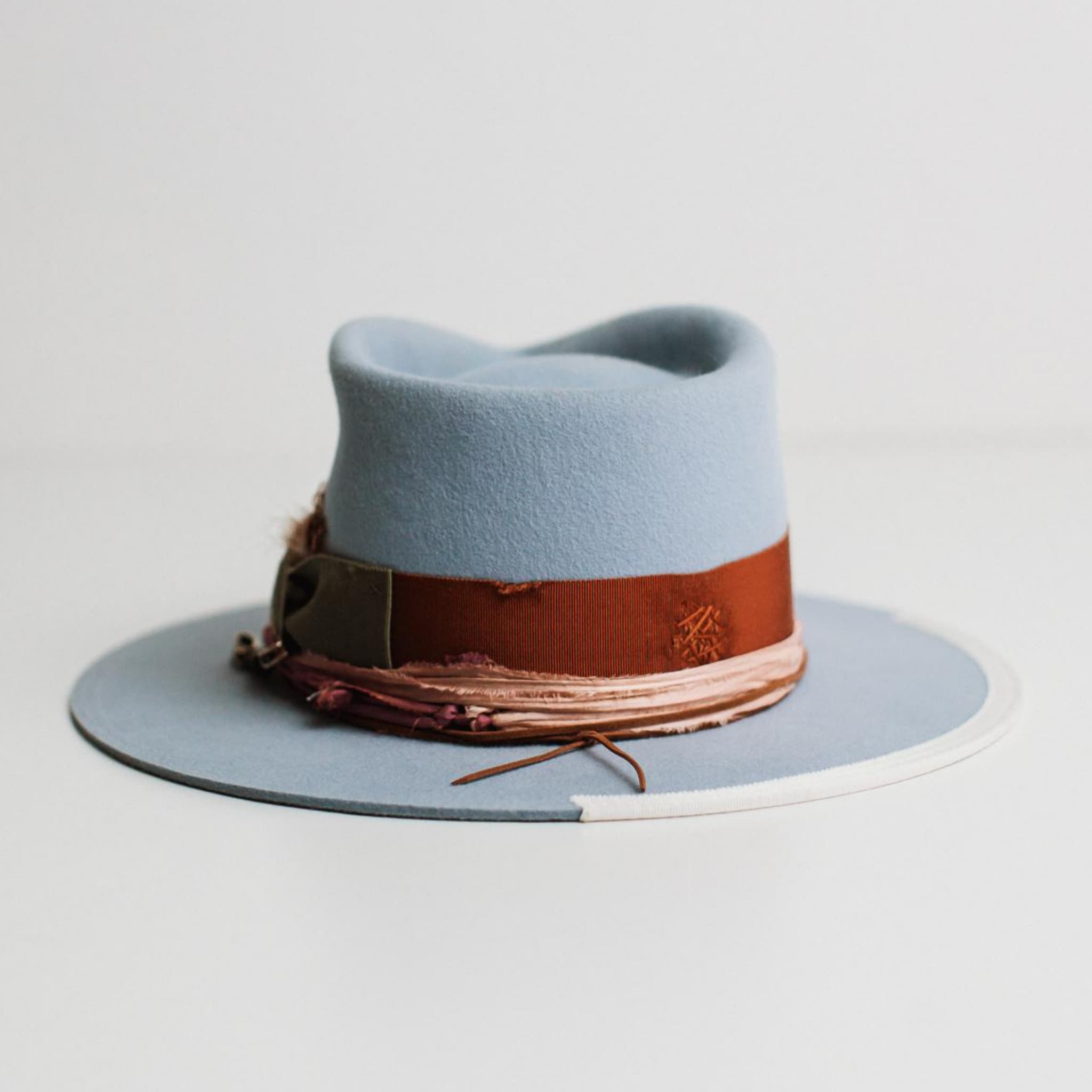 Back view of Santa Monica crystal blue felt hat by PHYLLi Designs with rust grosgrain band and sari silk trim.
