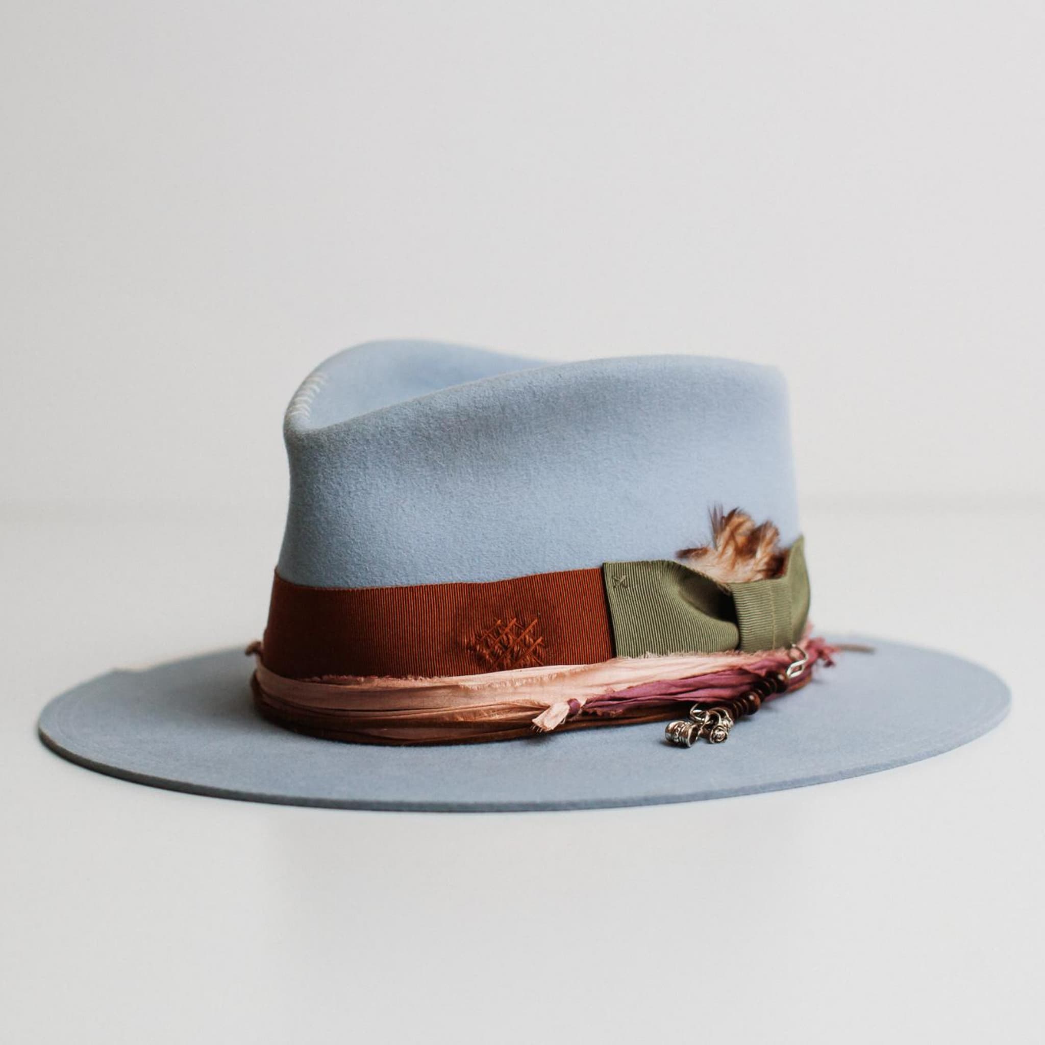 Front left angle of Santa Monica crystal blue felt hat by PHYLLi Designs with rust grosgrain band and ivory brim trim.