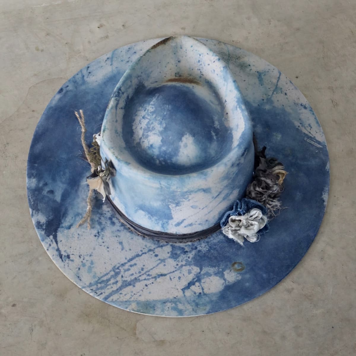 Top down back view of the dove grey indigo tie dye felt hat Shibori Limited Edition by PHYLLi Designs with sari silk blooms and trim.