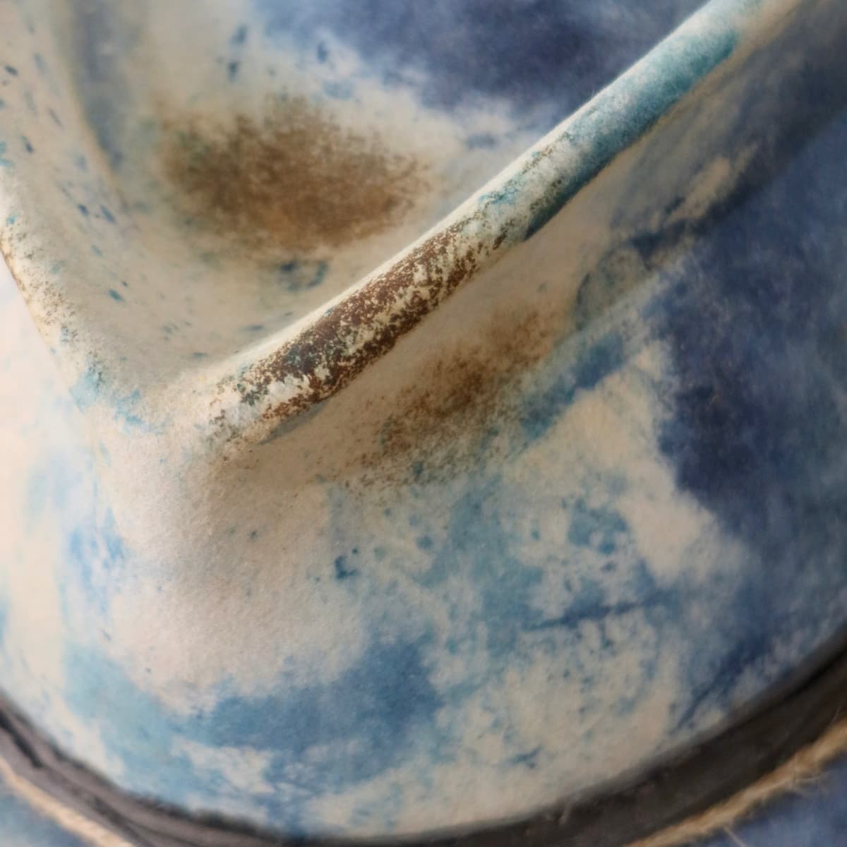 Close up detail of the Shibori Limited Edition felt hat showing hand distressed indigo dye finish.