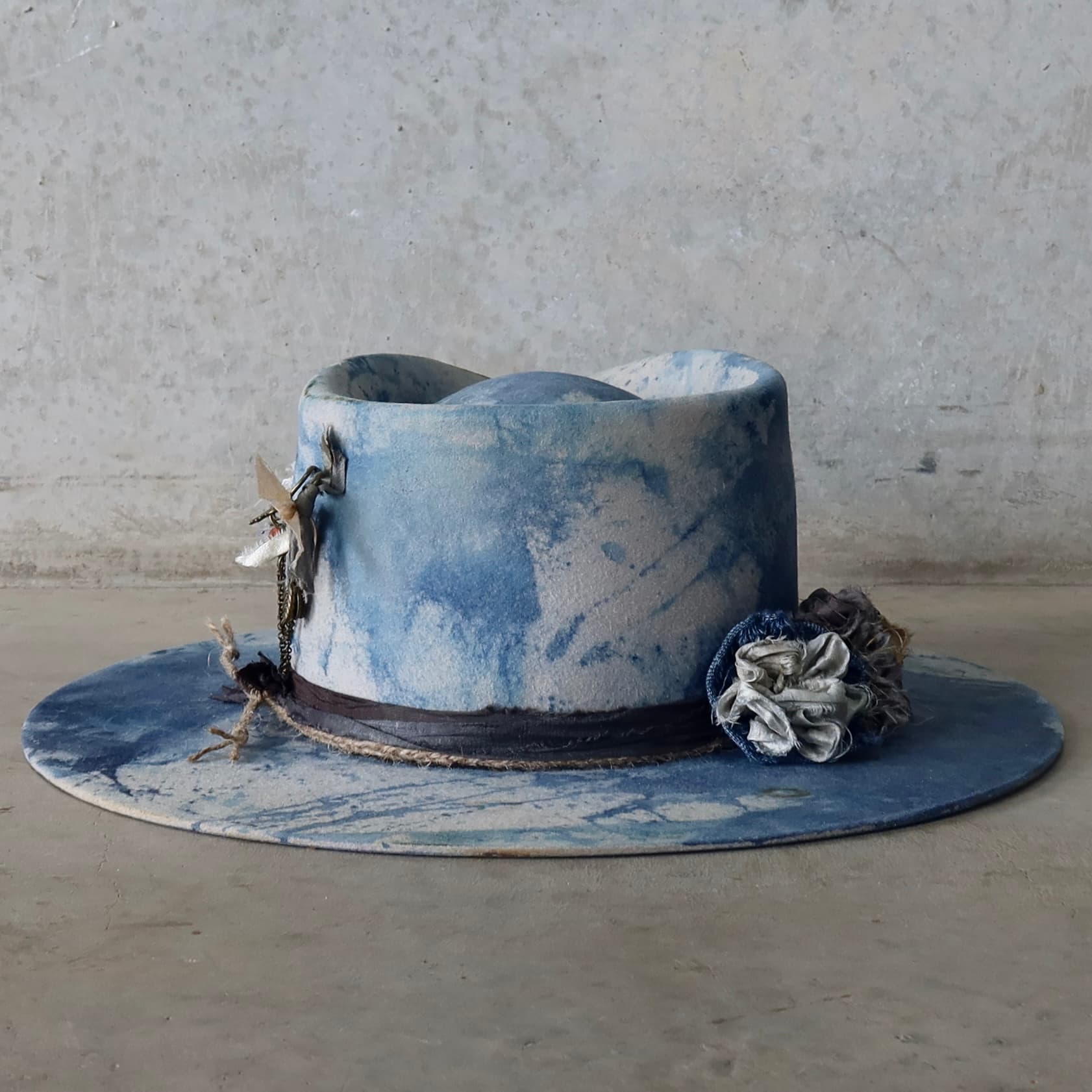 Back view of the dove grey indigo tie dye felt hat Shibori Limited Edition by PHYLLi Designs featuring sari silk trimming and twine wraps.